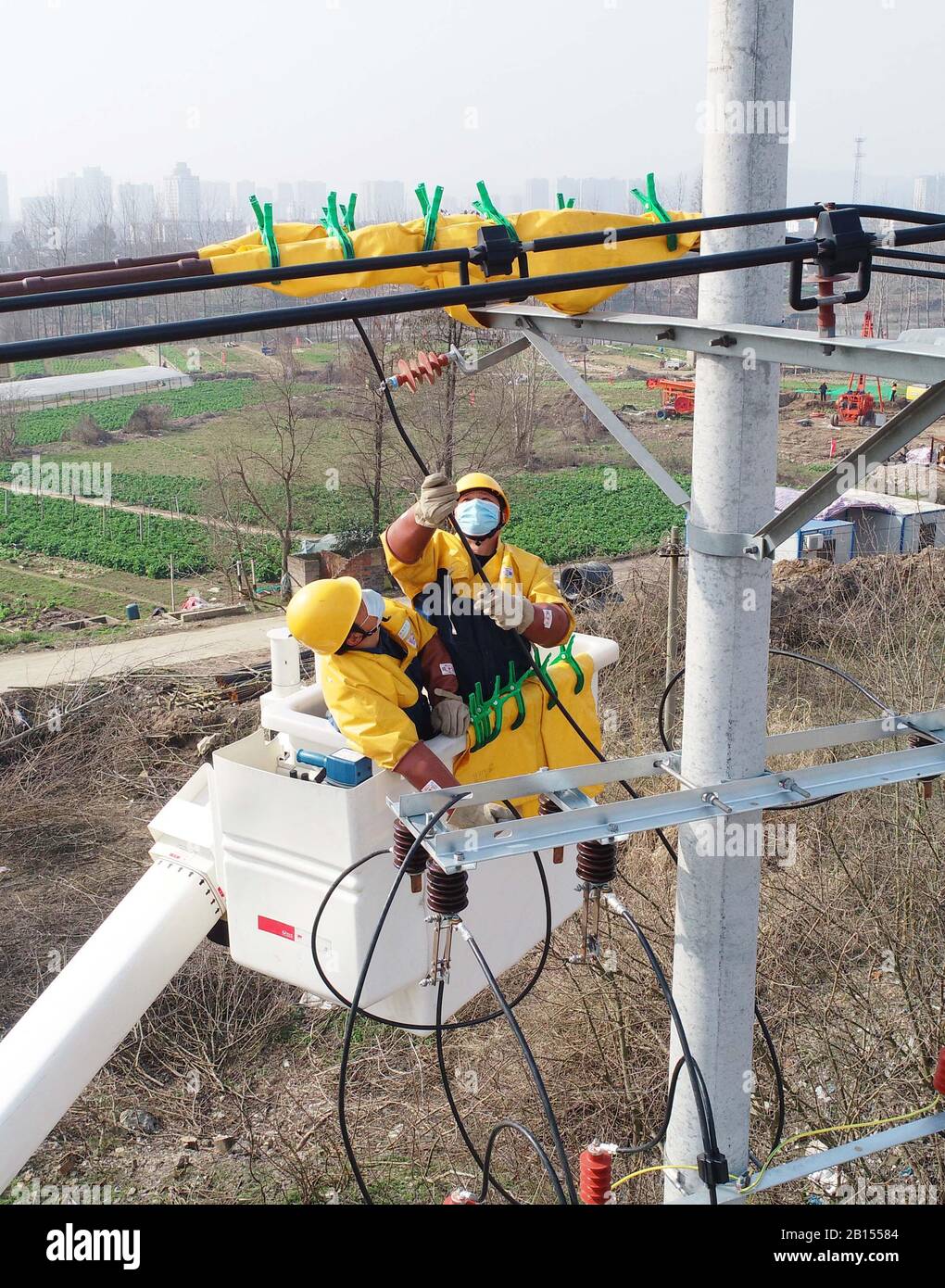 Chinese electricians perform live working on electric transmission lines to secure power supply in Langya District, Chuzhou City, east China's Anhui P Stock Photo