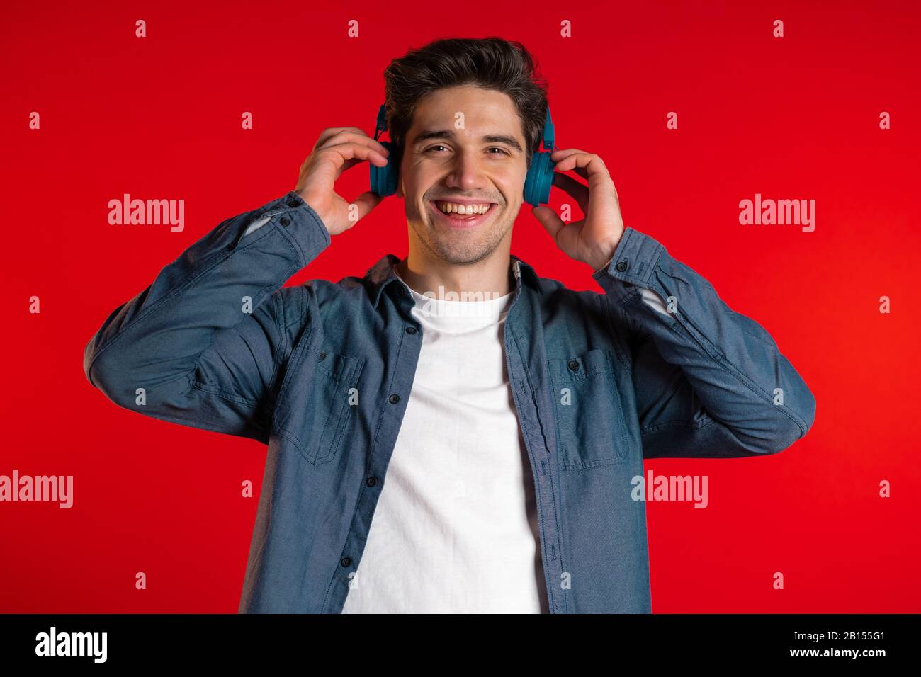 Handsome man with headphones dancing isolated on red background. Party,  music, lifestyle, radio and disco concept Stock Photo - Alamy