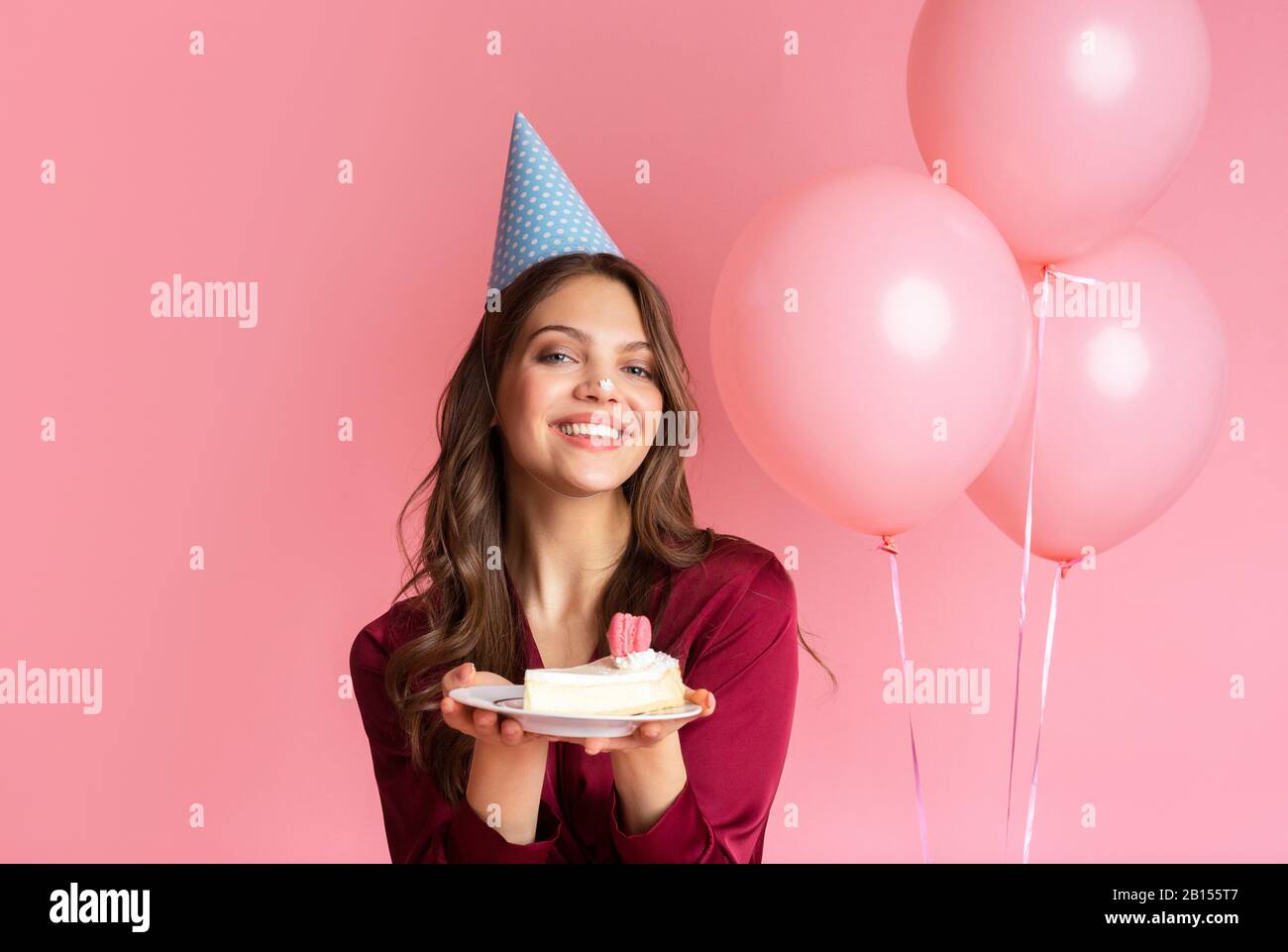 Cute Asian birthday girl looks with temptation at camera licks lips wants  to eat delicious cake has special occasion celebrates 26th bday holds  inflated balloon enjoys festive party poses indoor Stock Photo |