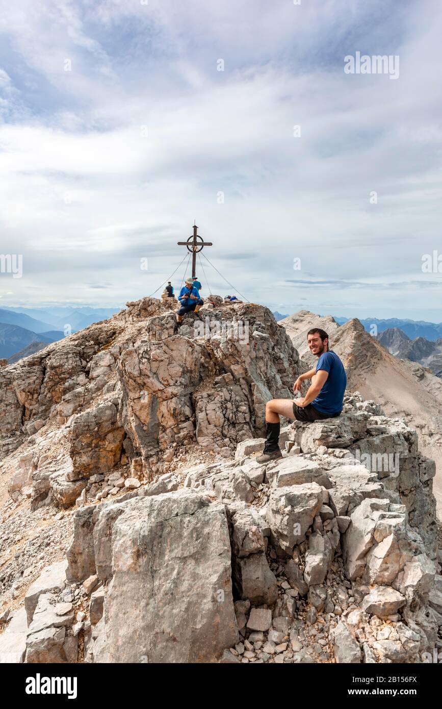 Hiker takes a break at the summit of the Birkkarspitze, Karwendeltal, Tyrol, Austria Stock Photo