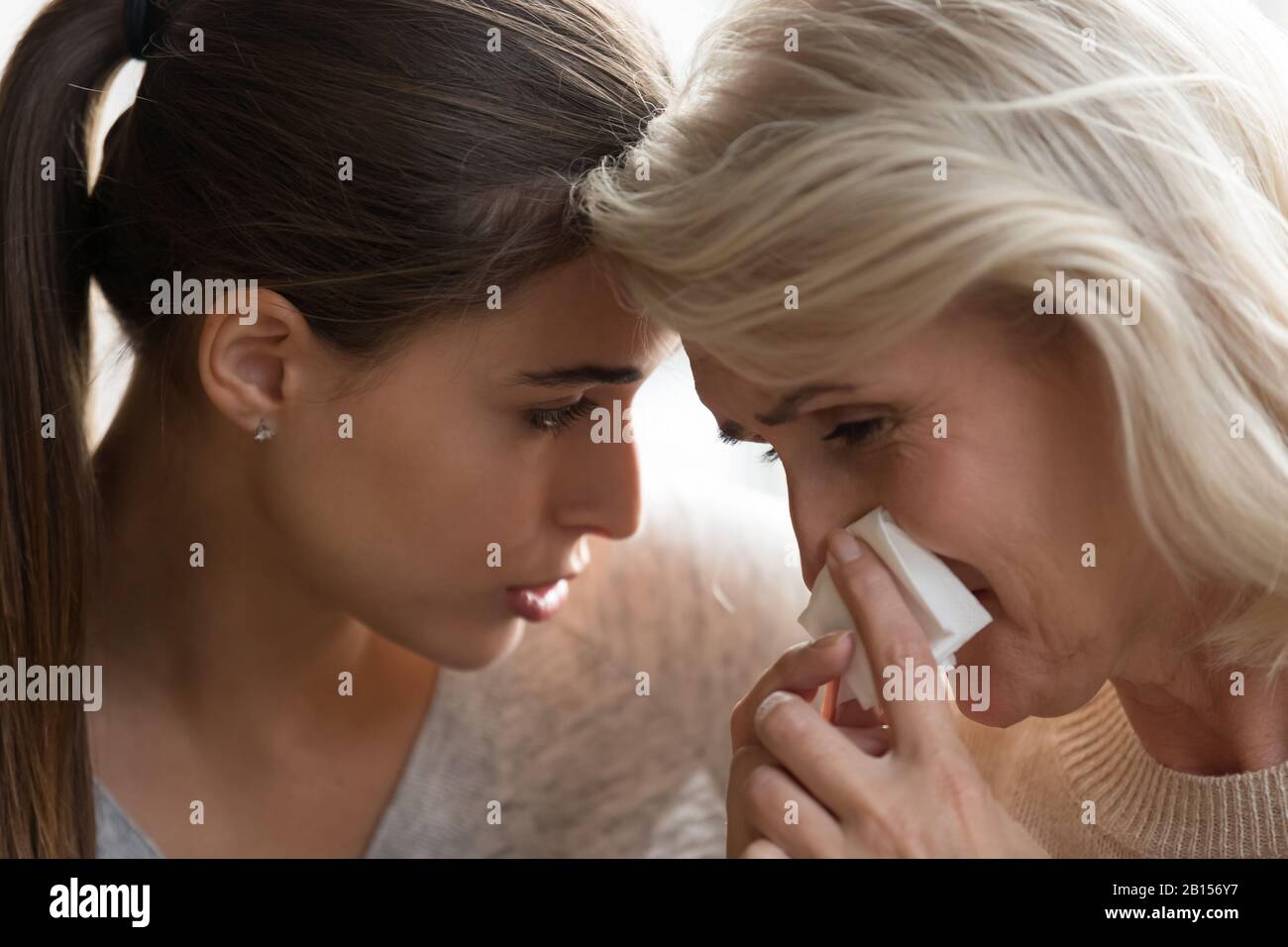 Millennial serious worried woman comforting crying mommy. Stock Photo