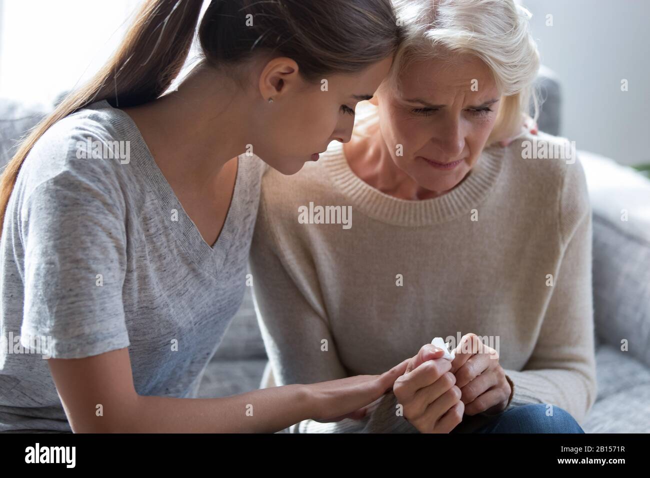 Worrying millennial lady sitting next to upset frustrated mommy. Stock Photo