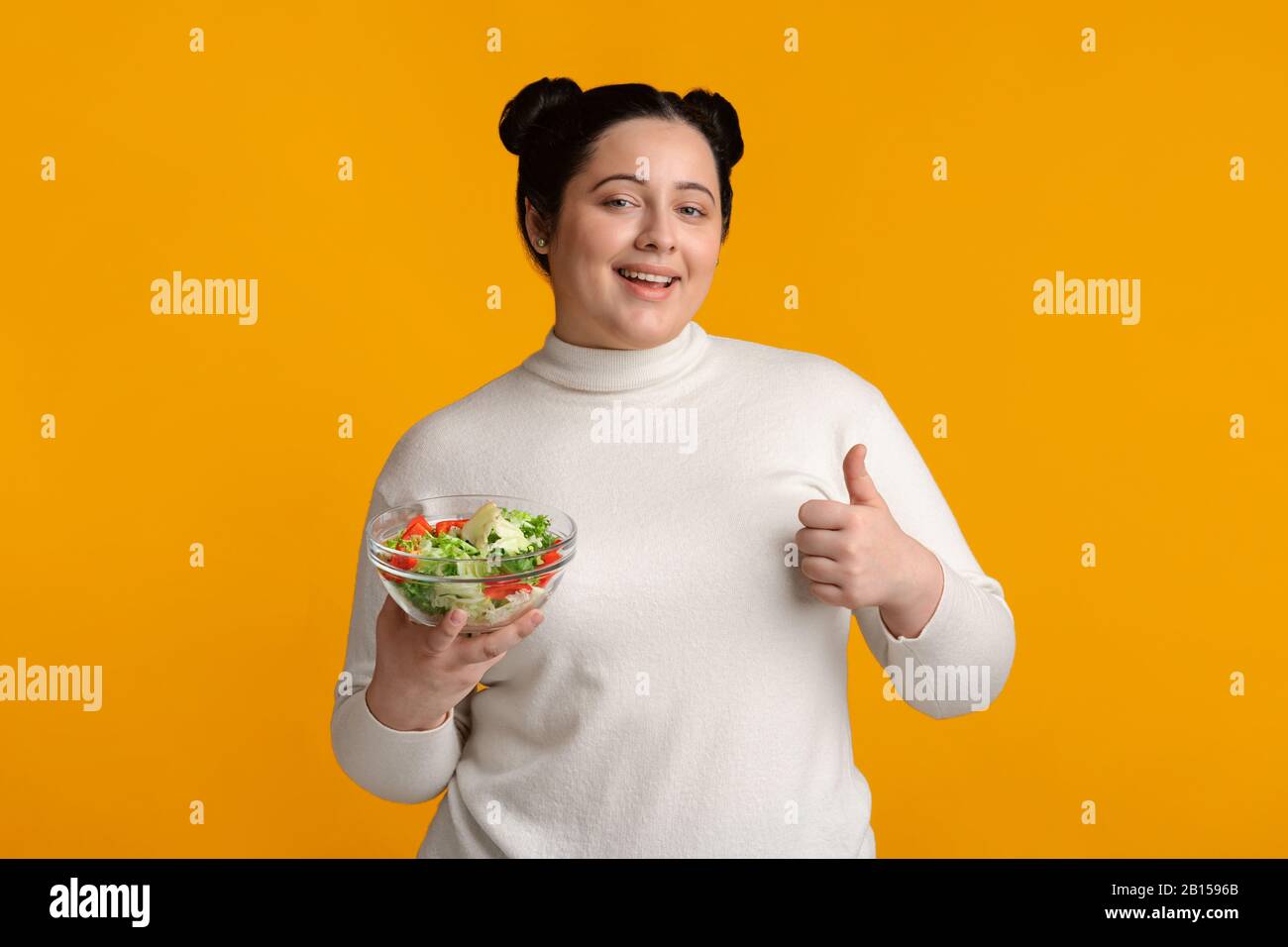 Overweight Woman Holding Bowl With Vegetable Salad And Showing Thumb Up Stock Photo