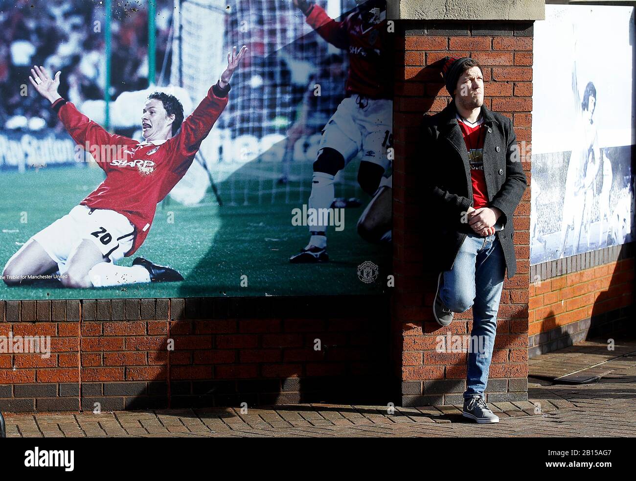 A fan near a picture of Ole Gunnar Solskjaer outside the ground before the Premier League match at Old Trafford, Manchester. Stock Photo