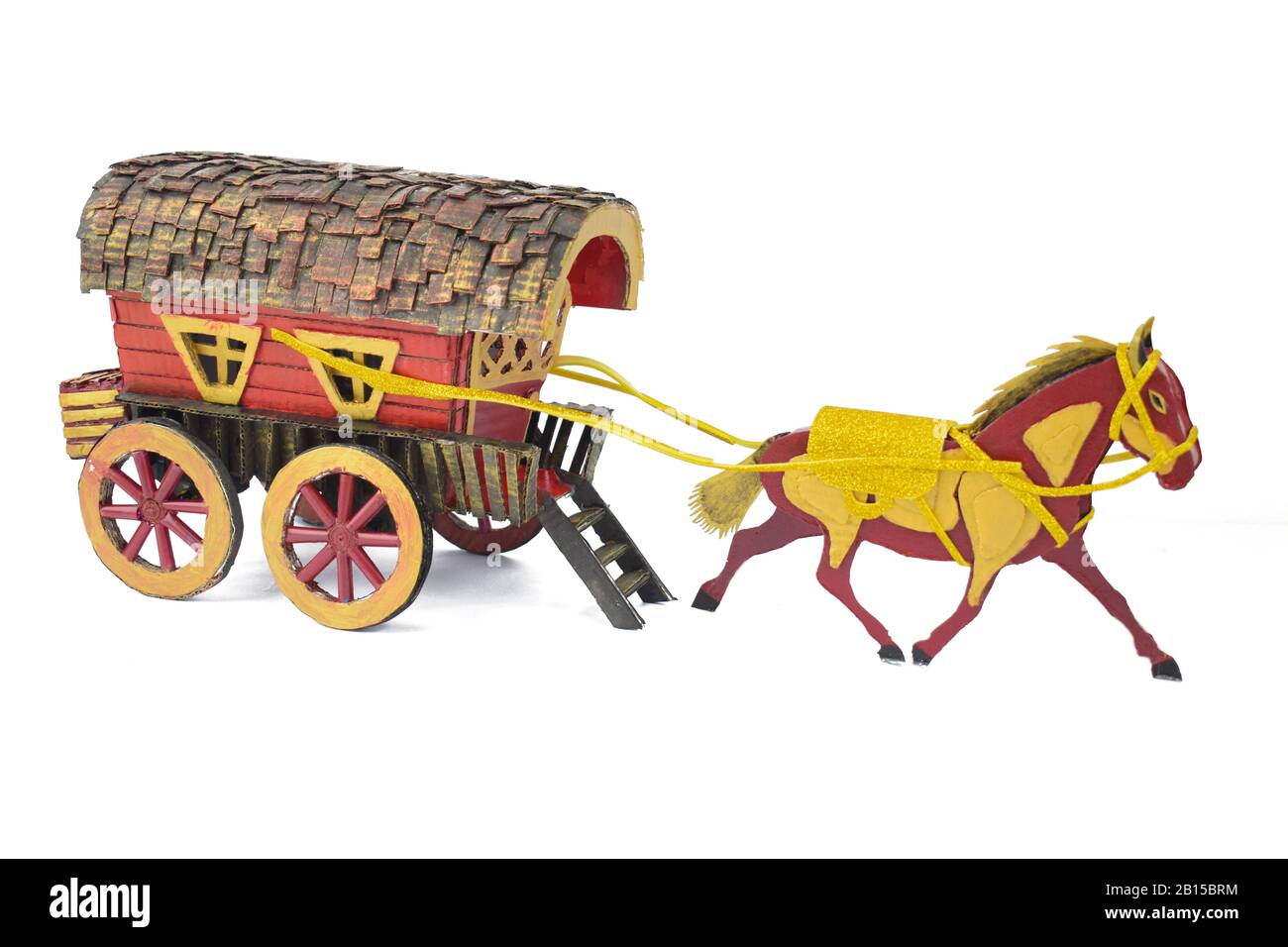Display of a crafted horse made of card board pulling a carriage made of the same cardboard before a white background Stock Photo