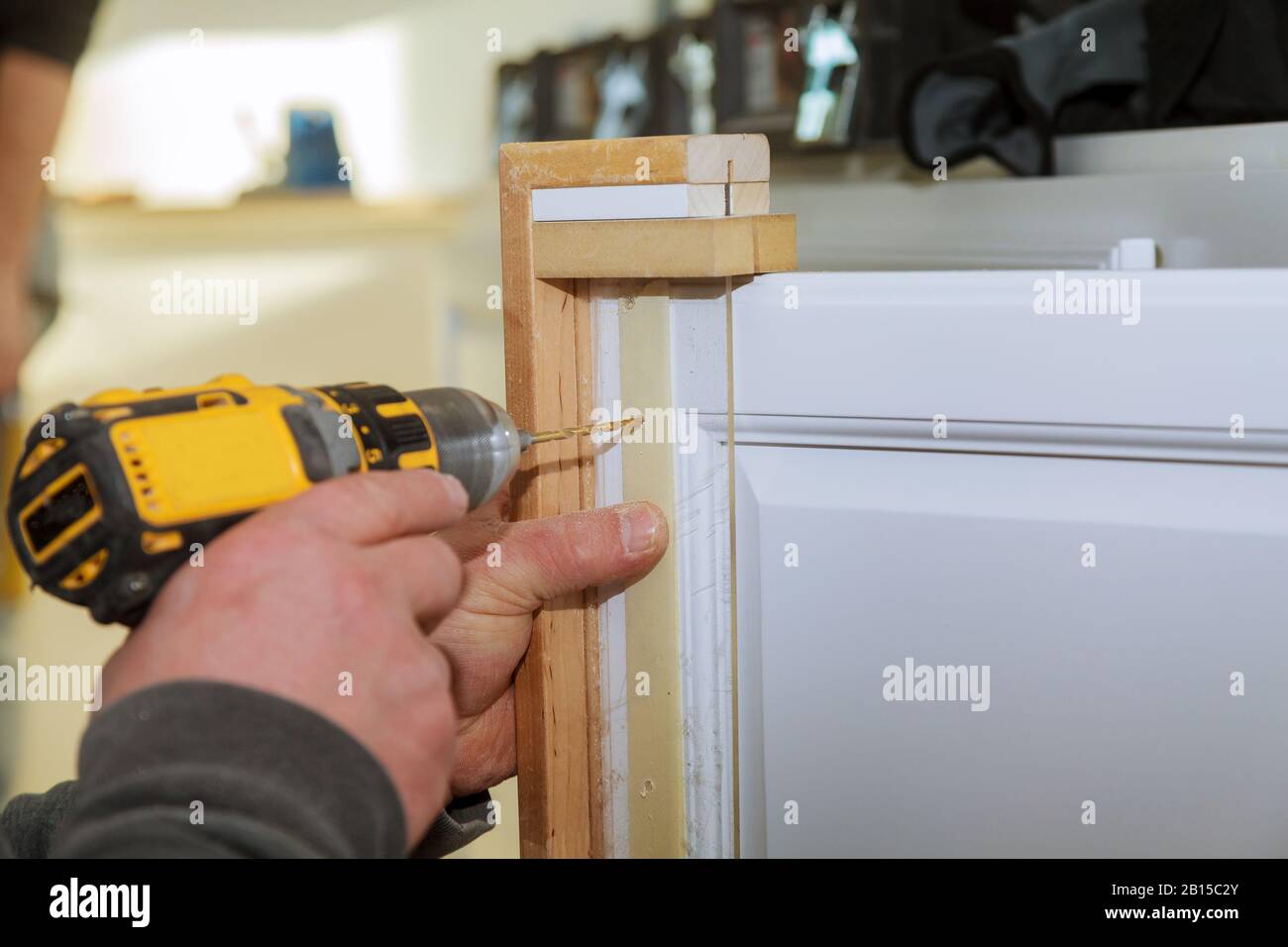 door master drills the drilling a hole door Stock Photo Alamy
