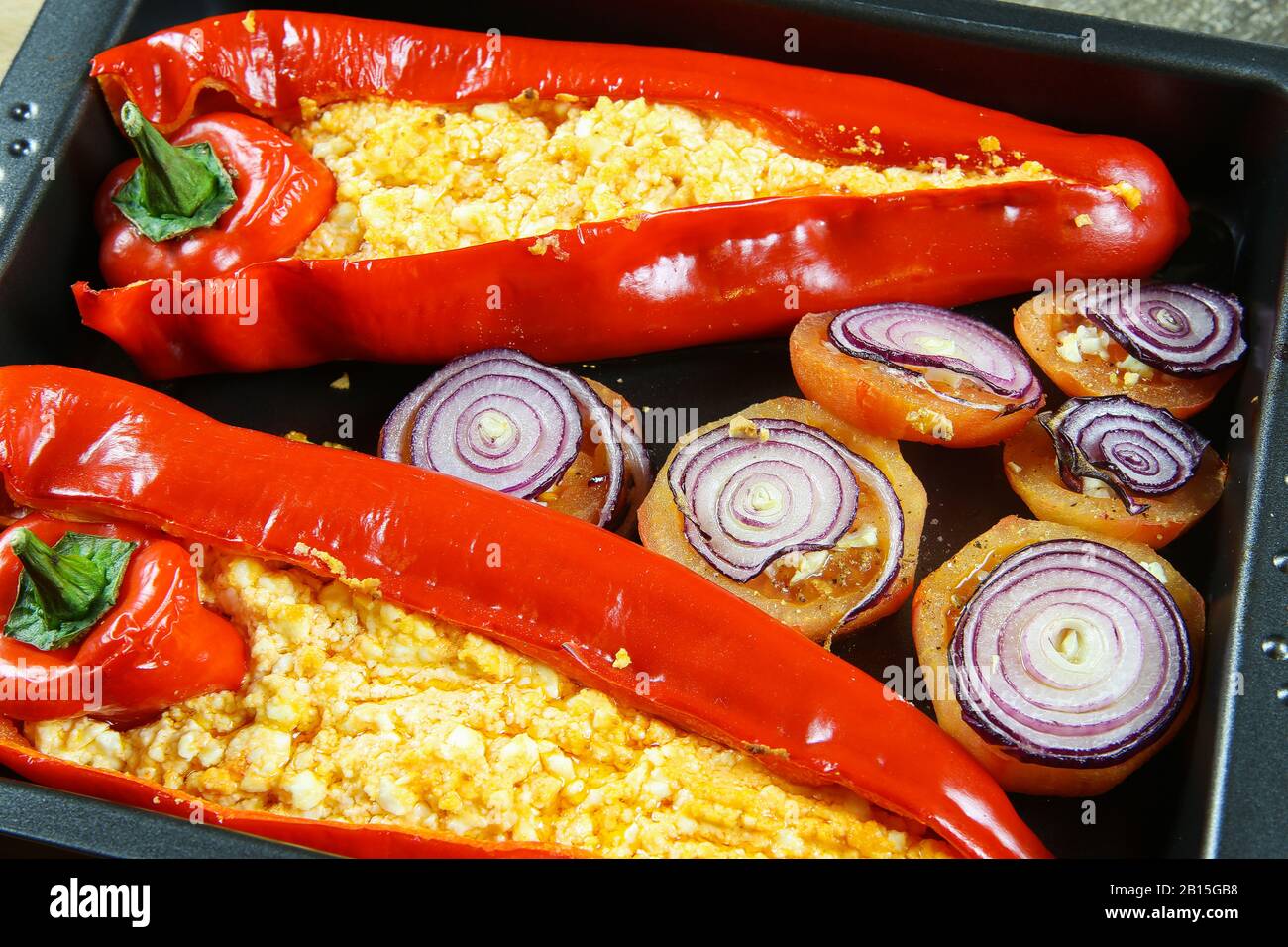 Close up of two baked red bell peppers filled with spicy chili feta and