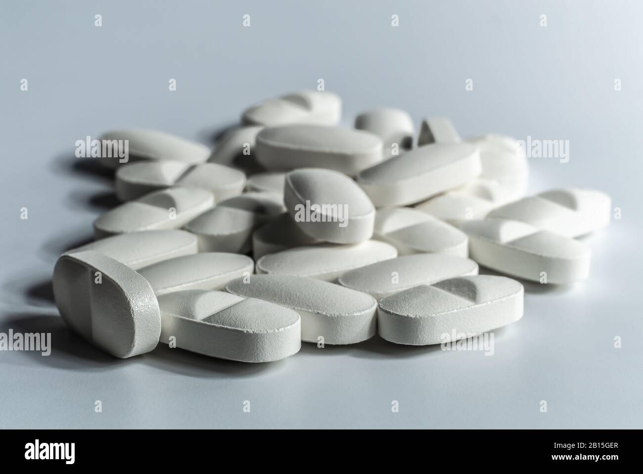 Closeup of many prescription drugs, medicine tablets or vitamin pills in a pile on white background - Concept of healthcare, opioids addiction Stock Photo