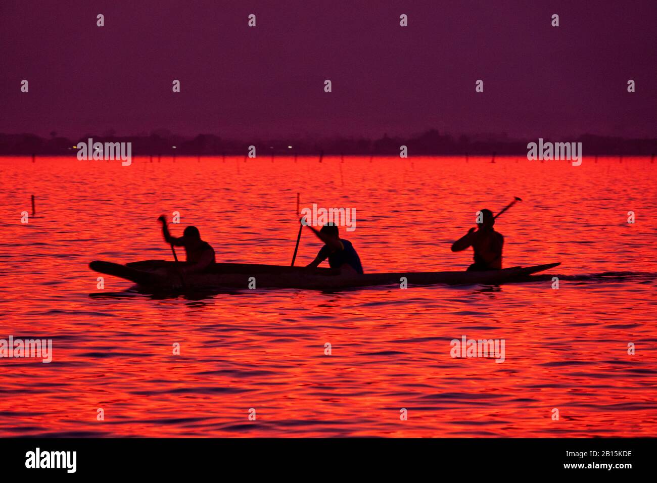 Silhouette of Sportsmen practicing canoeing on Kwan Phayao, Phayao, Thailand Stock Photo