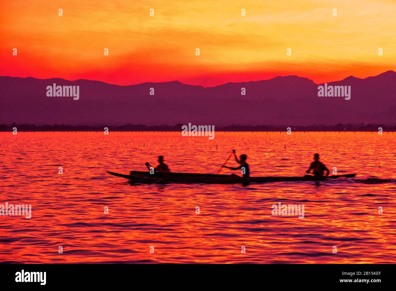 Silhouette of Sportsmen practicing canoeing on Kwan Phayao, Phayao, Thailand Stock Photo