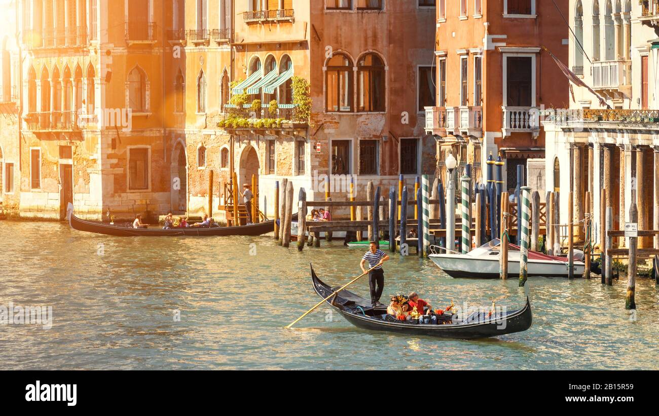 Venice, Italy - May 21, 2017: Gondolas with tourists sailing along the Grand Canal in Venice. Romantic water trip on a gondola in beautiful Venice. Pa Stock Photo