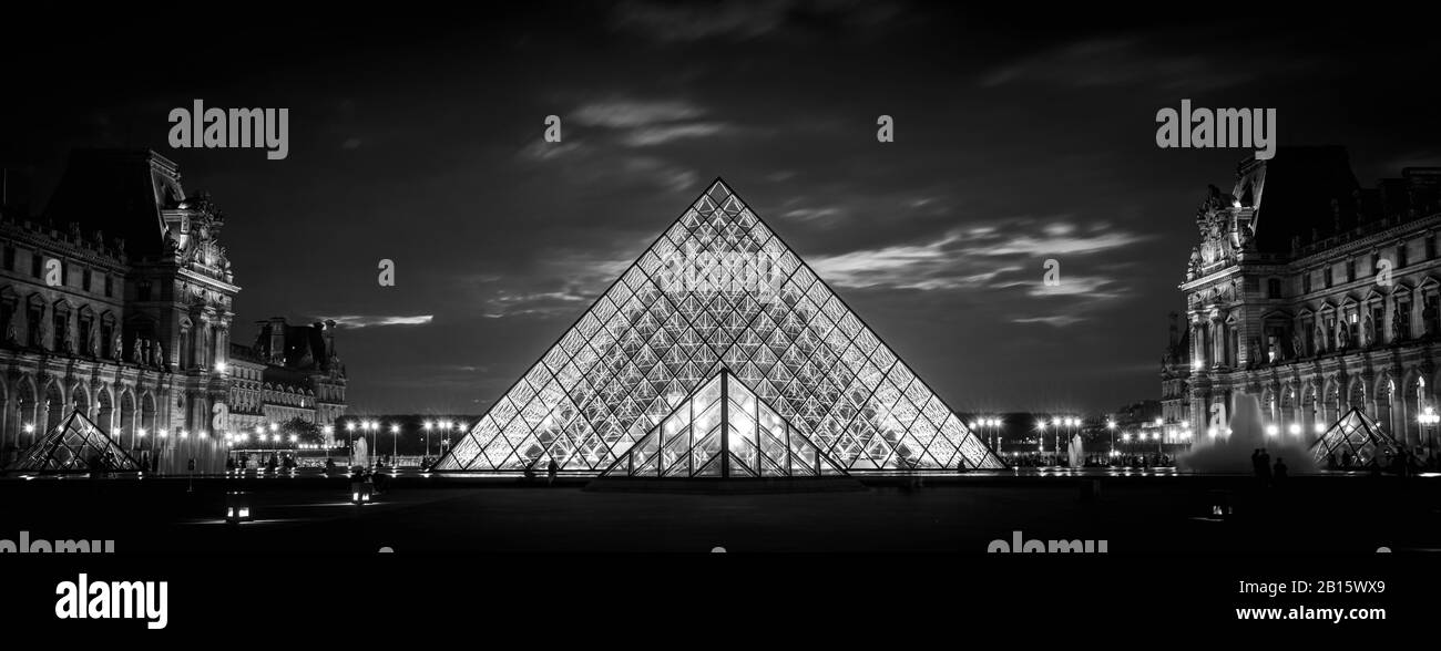 Paris - Sep 25, 2013: Louvre museum at night in Paris. Famous Louvre is one of top tourist destinations in France. Panoramic view of illuminated Louvr Stock Photo