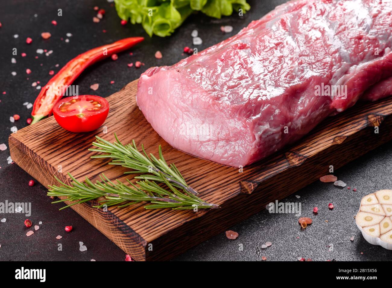 Fresh pieces pork ready to cook on a dark background in the kitchen