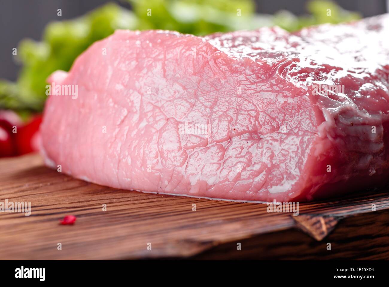 Fresh pieces pork ready to cook on a dark background in the kitchen