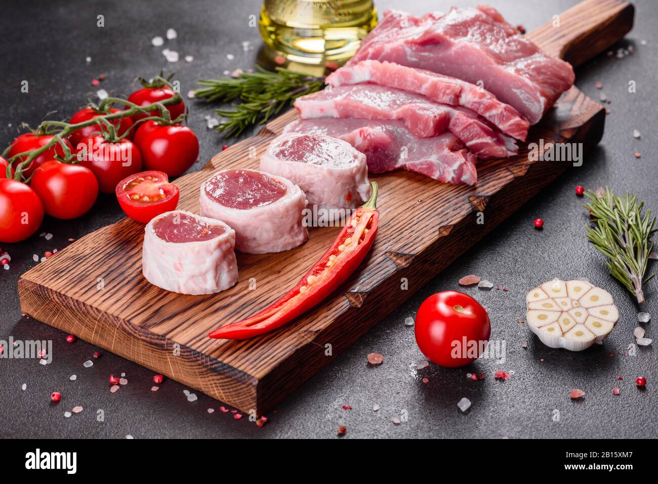 Fresh pieces pork ready to cook on a dark background in the kitchen