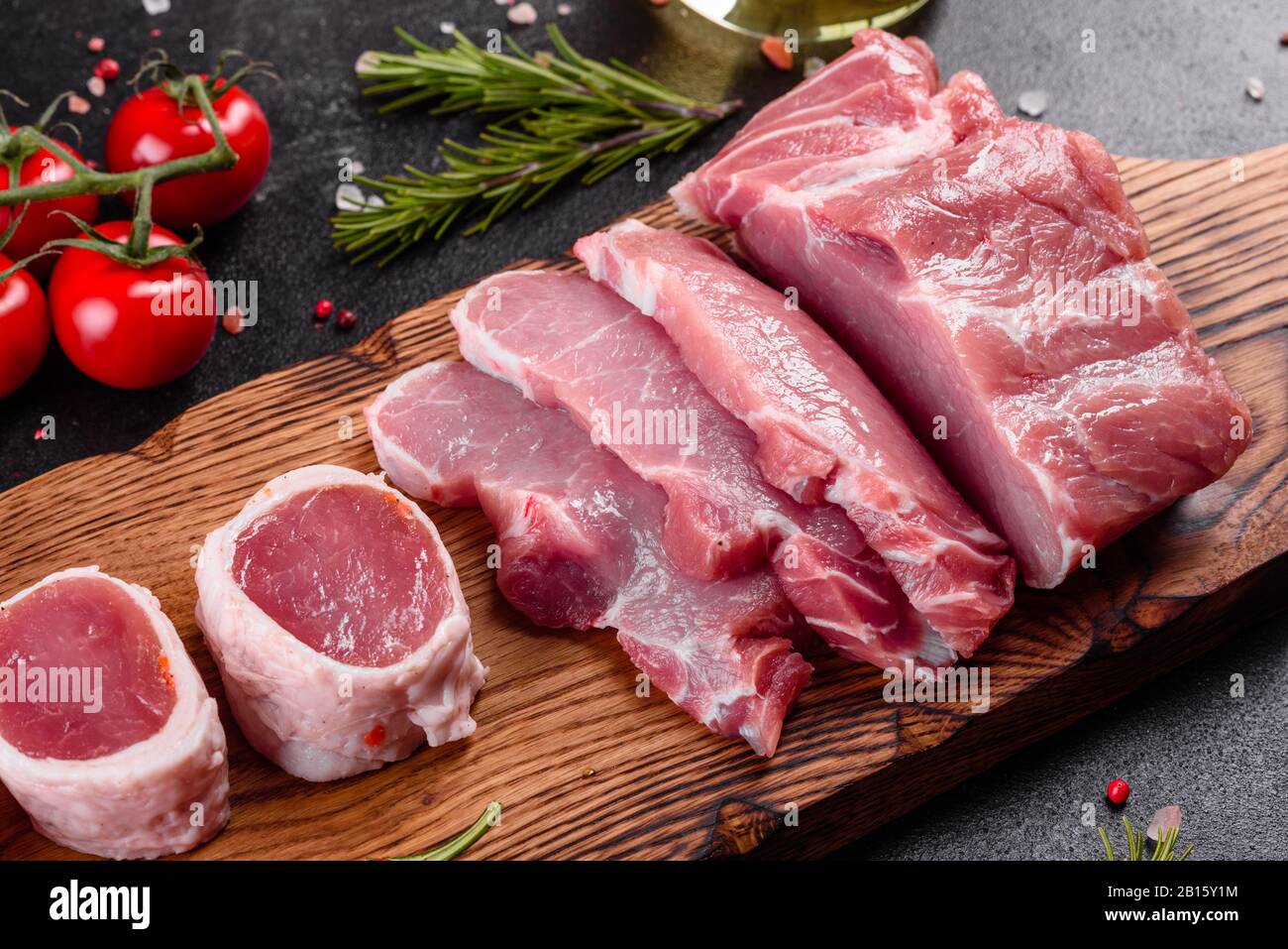 Fresh pieces pork ready to cook on a dark background in the kitchen