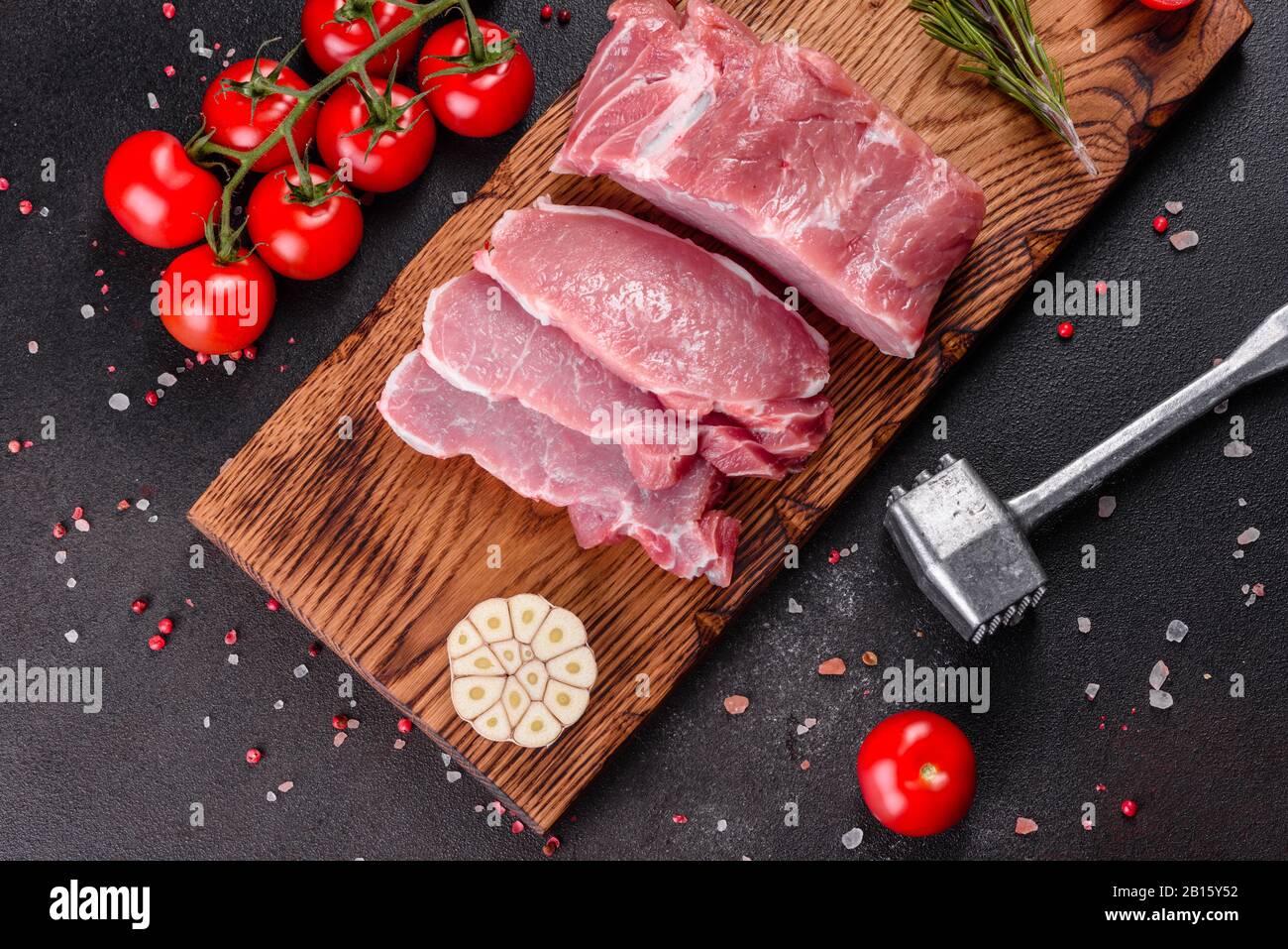 Fresh pieces pork ready to cook on a dark background in the kitchen