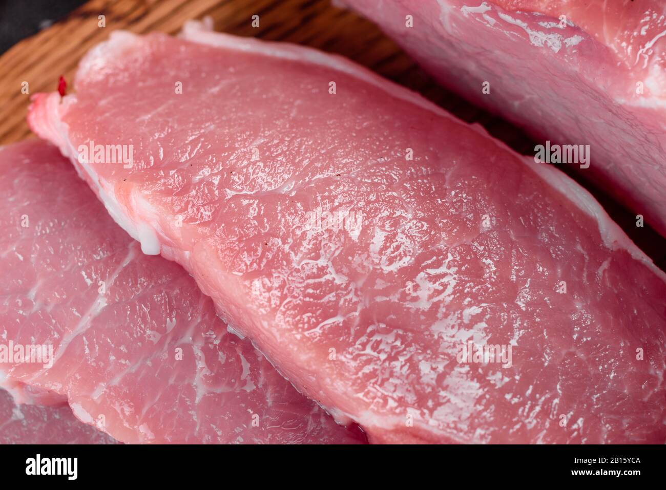 Fresh pieces pork ready to cook on a dark background in the kitchen