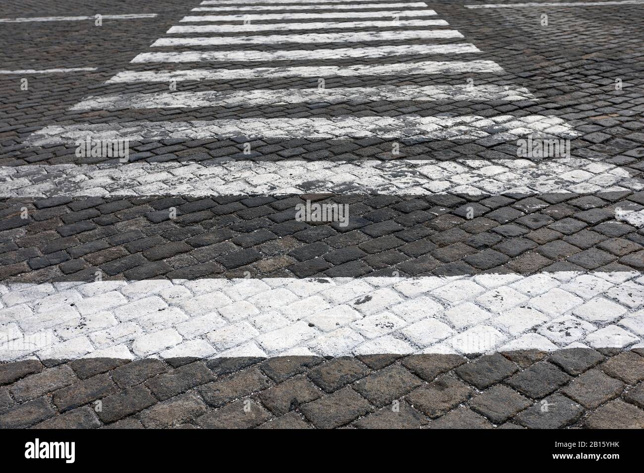 A grey paved street with a white pedestrian walkway Stock Photo
