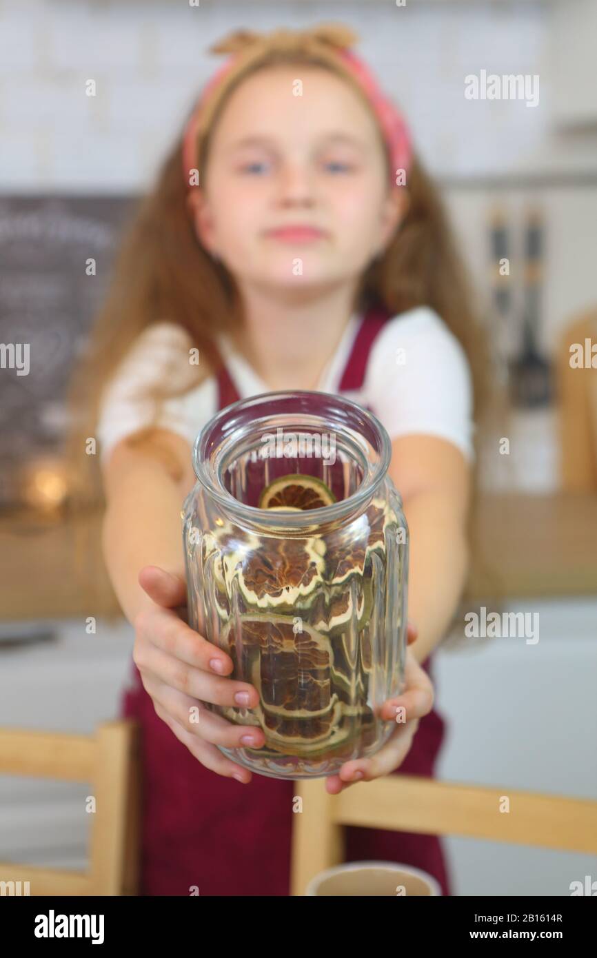 Children's hands hold a glass jar with dried oranges Stock Photo Alamy