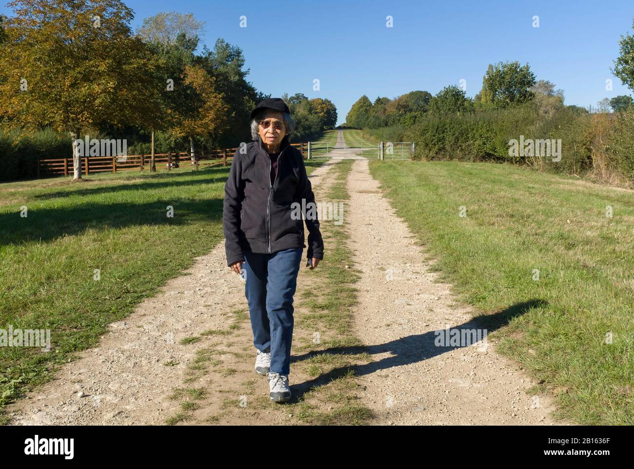 Active senior citizen, an Indian woman's daily fitness regime, walking outdoors as part of a healthy lifestyle, UK Stock Photo