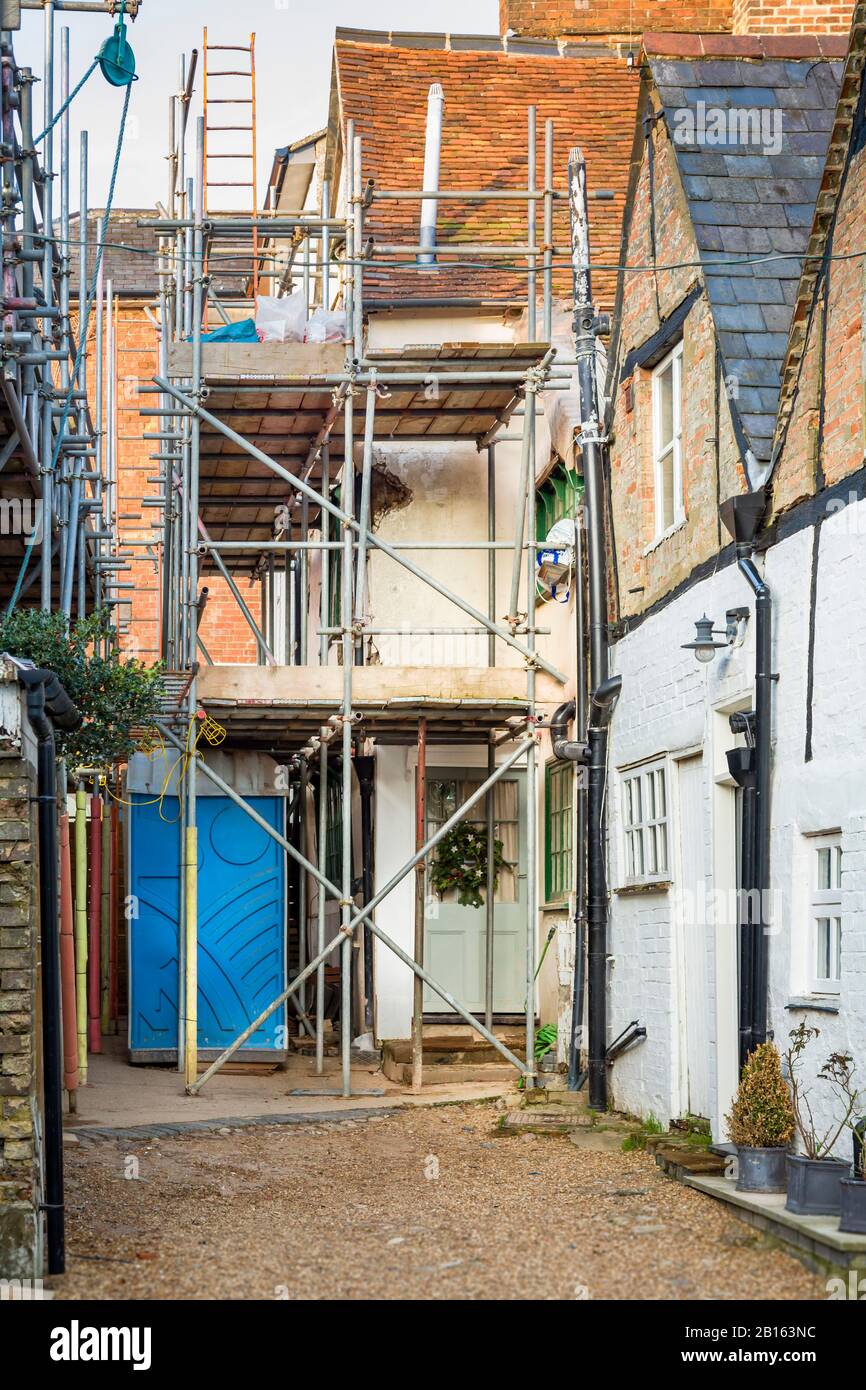 English house with scaffolding having building work and roof renovations, UK Stock Photo
