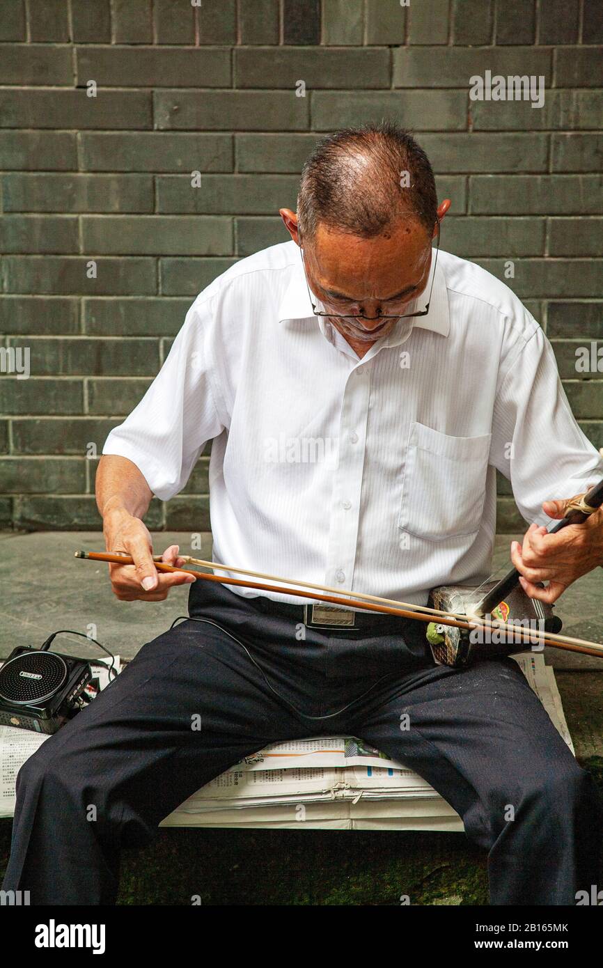Chinese man playing an Erhu traditional stringed instrument in Chengdu People's Park China Stock Photo