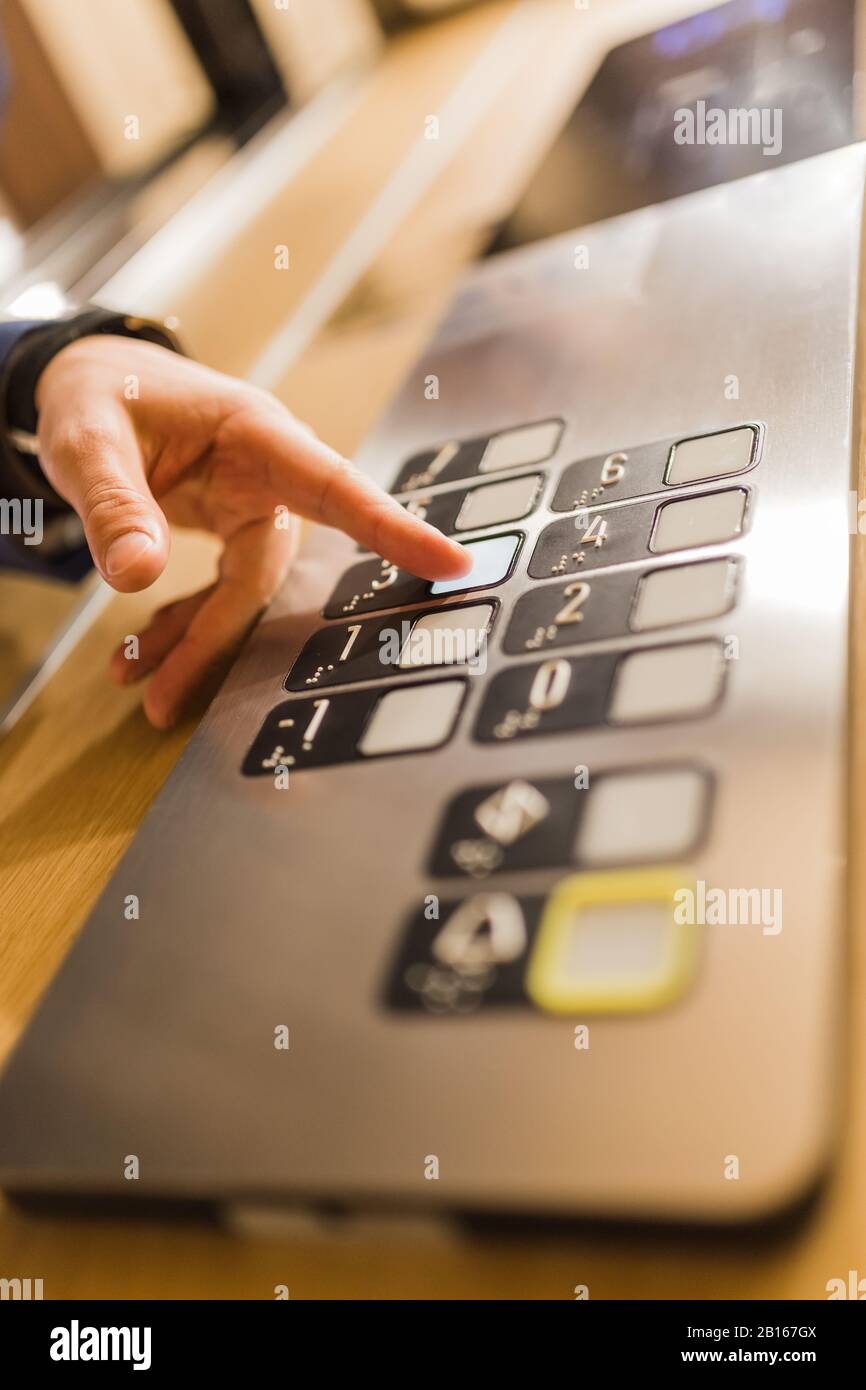 Man pressing modern elevator button with his forefinger. Stock Photo