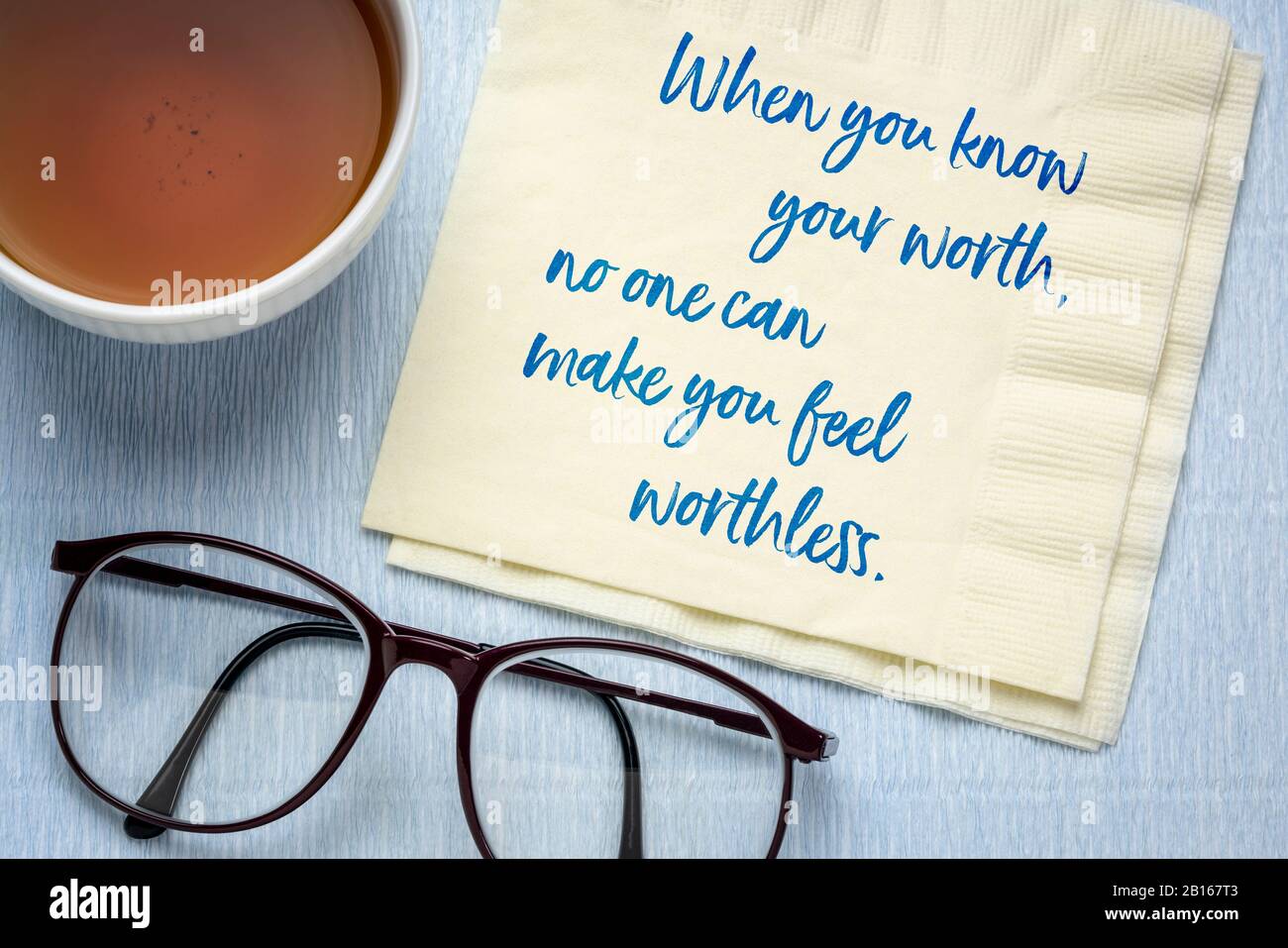 When you know you worth, no one can make you feel worthless - inspirational advice, handwriting on a napkin with a cup of tea, personal development an Stock Photo