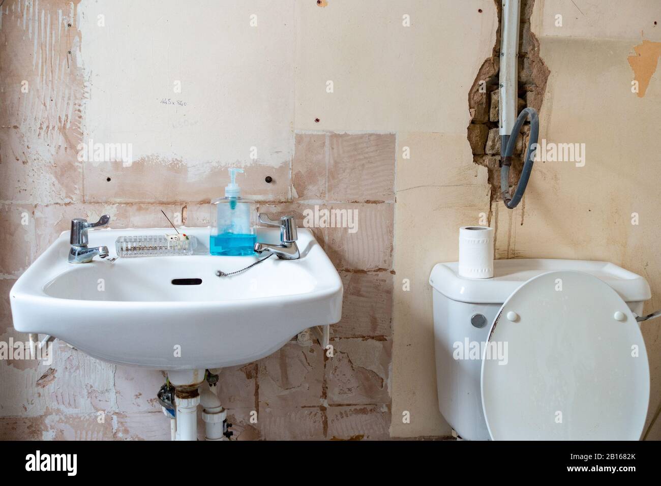 A Bathroom Stripped Bare As It Is Being Refurbished And Modernised Pipes Plumbing And
