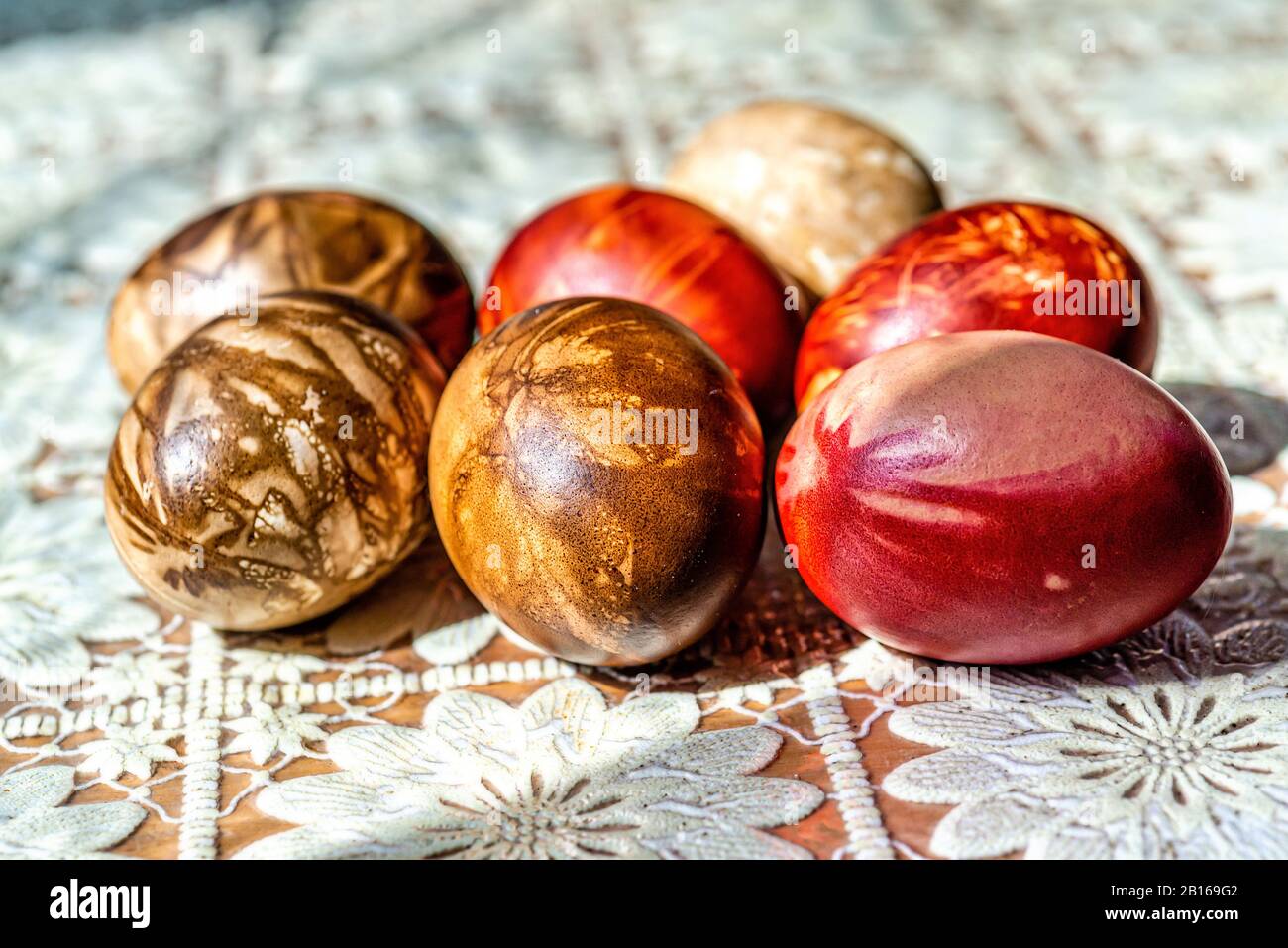 Multicolored easter eggs on a picnic table with a white tablecloth - image Stock Photo