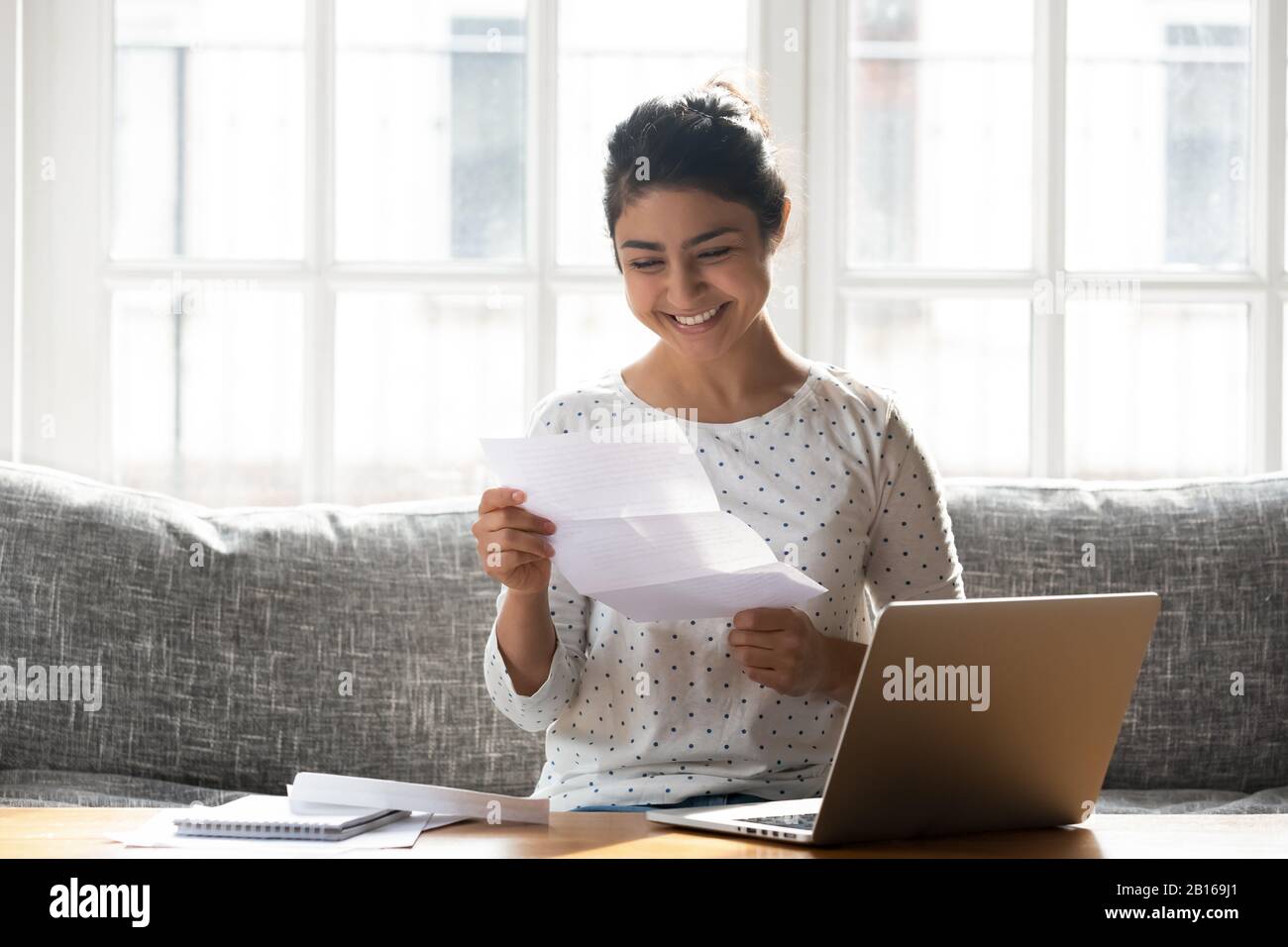 Happy woman holding paper reading good news college admission concept Stock Photo