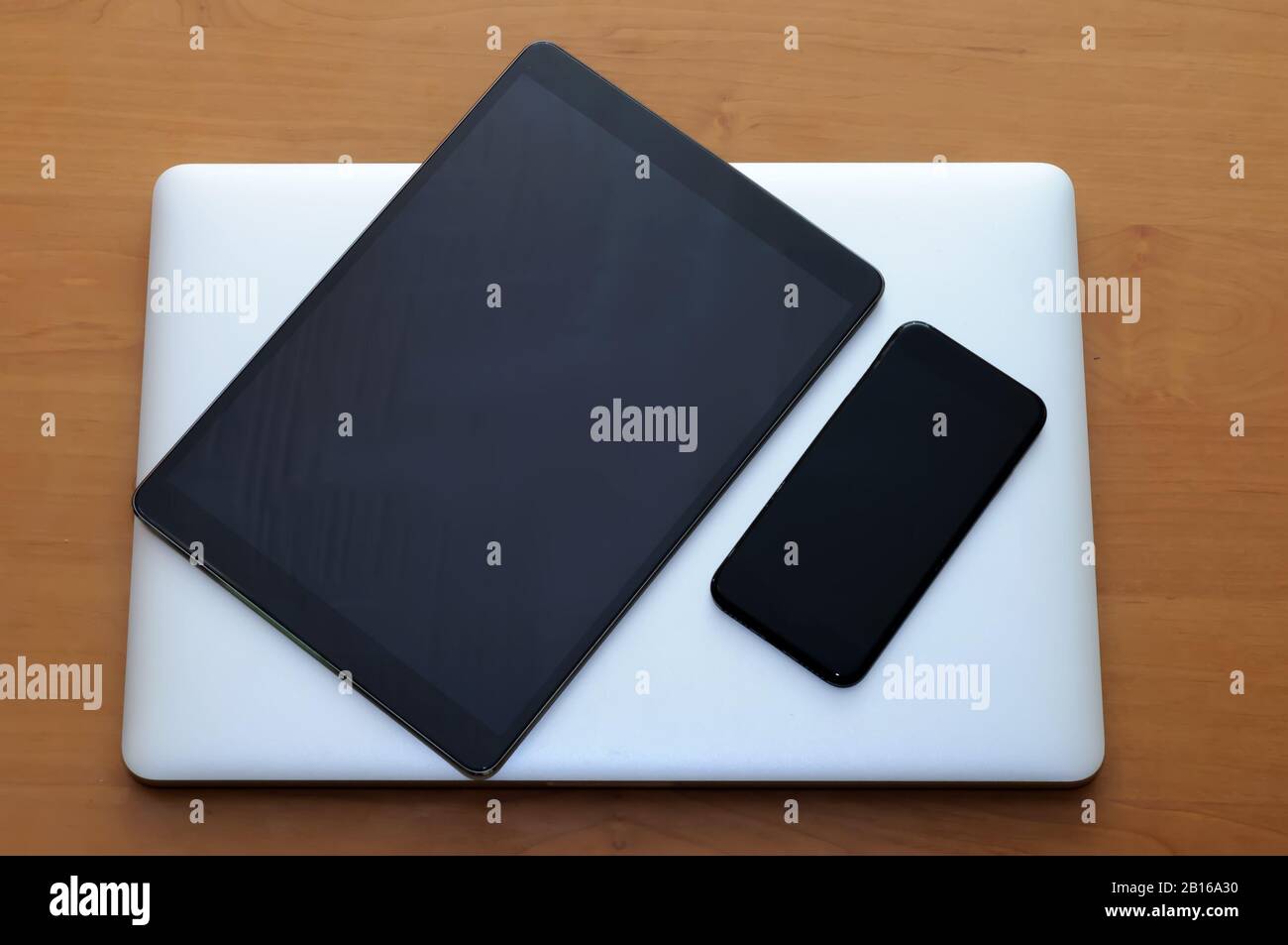 View on a closed laptop pc on a desk with a smartphone and tablet in a ...
