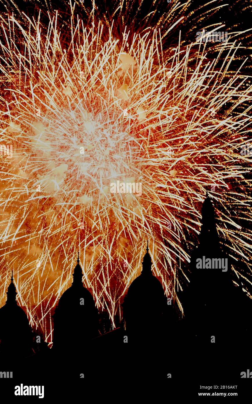 fireworks in a dark sky showing the silhouette of a domed building Stock Photo