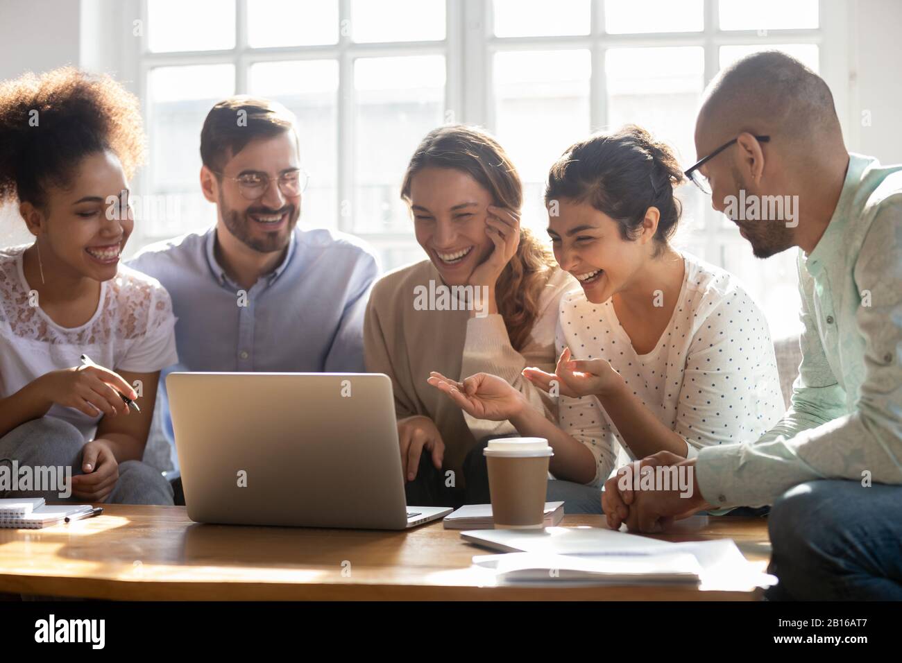 Multi-ethnic friends laughing enjoy comedy movie on computer Stock Photo
