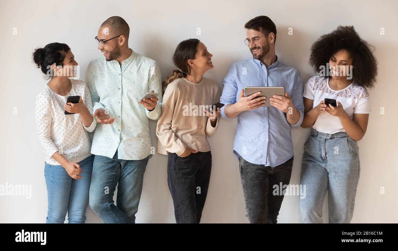 Cheerful friends with diverse modern gadget posing indoors Stock Photo