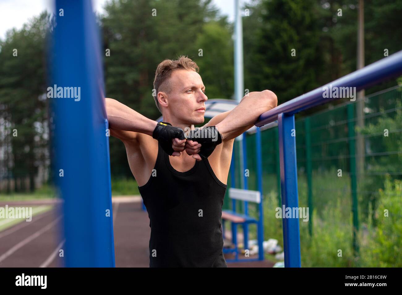 A man is pushing up from parallel bars Stock Photo