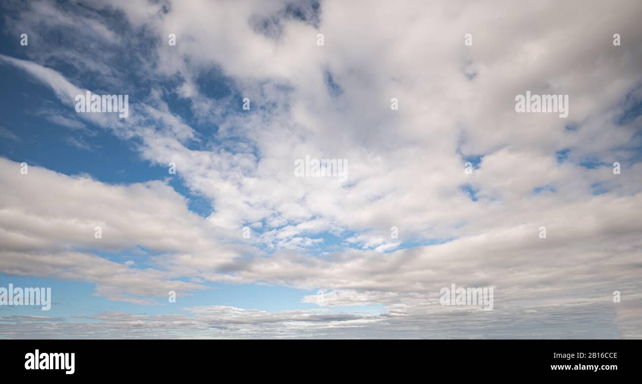 Bright blue sky with scattered clouds during a clear day Stock Photo