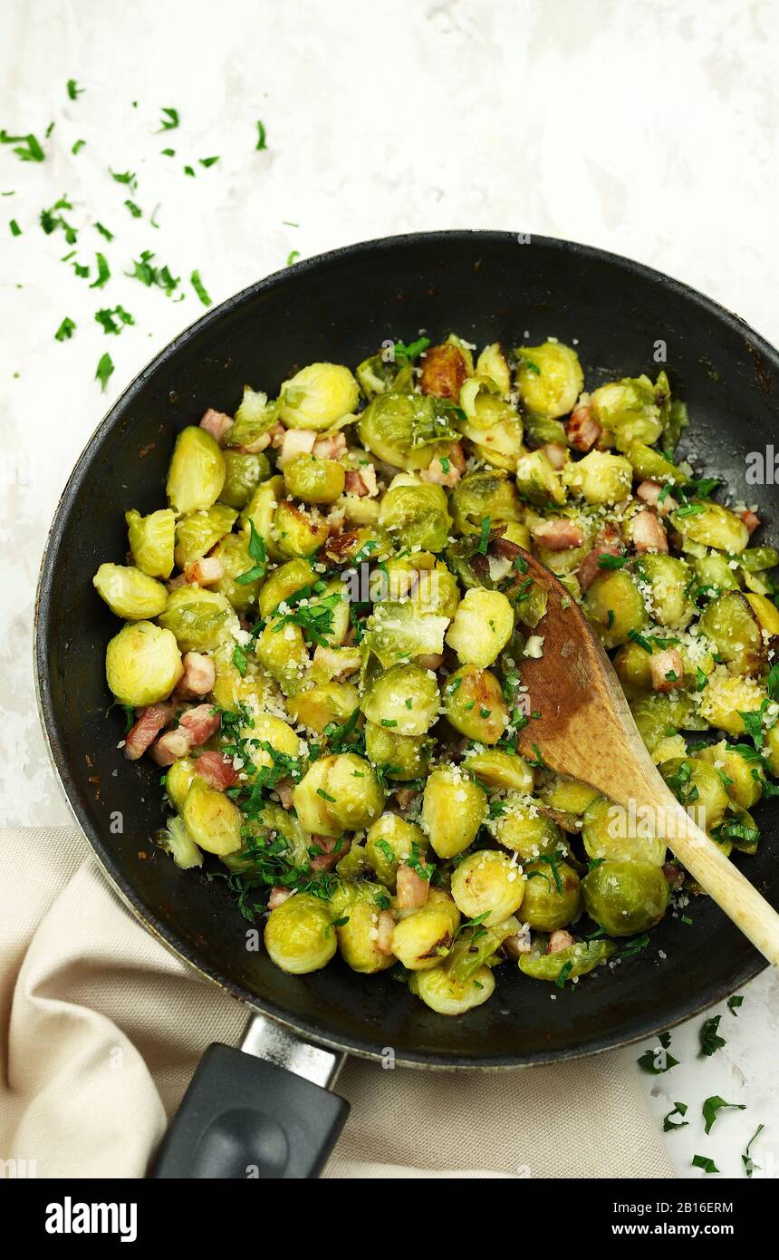 Frying pan with roasted Brussel sprouts on white background. Top view. Stock Photo