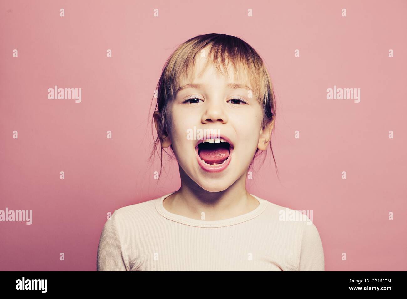 Child girl screaming on pink background Stock Photo Alamy