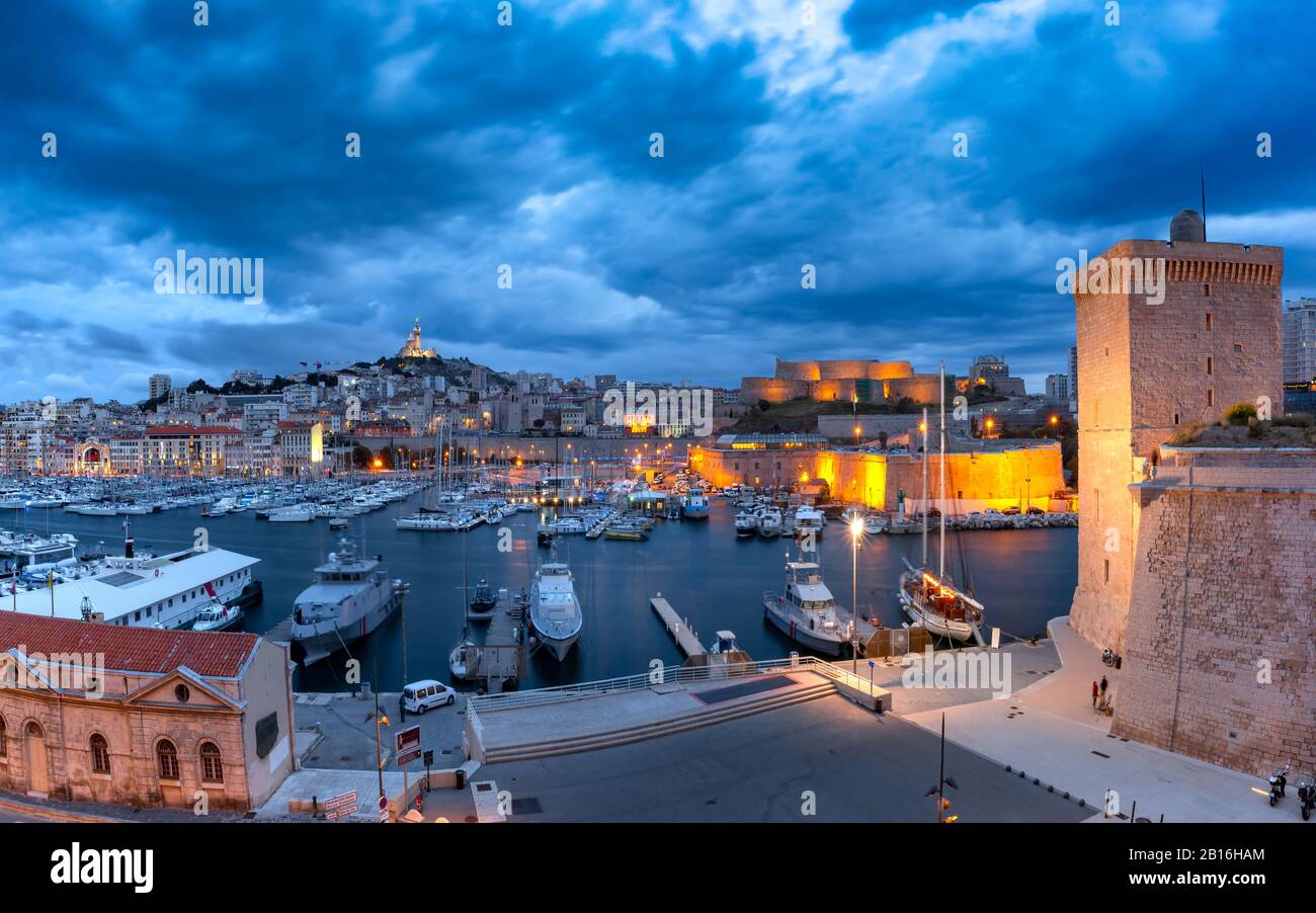 Night Old Port with Forts Saint-Jean and Saint-Nicolas, the Basilica of Notre Dame de la Garde on the background, on the hill, Marseille, France Stock Photo