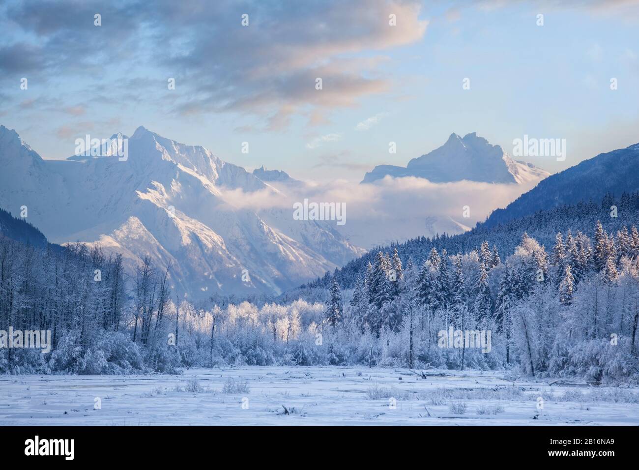 Beautiful winter scene with snow covered mountains and a frozen river ...