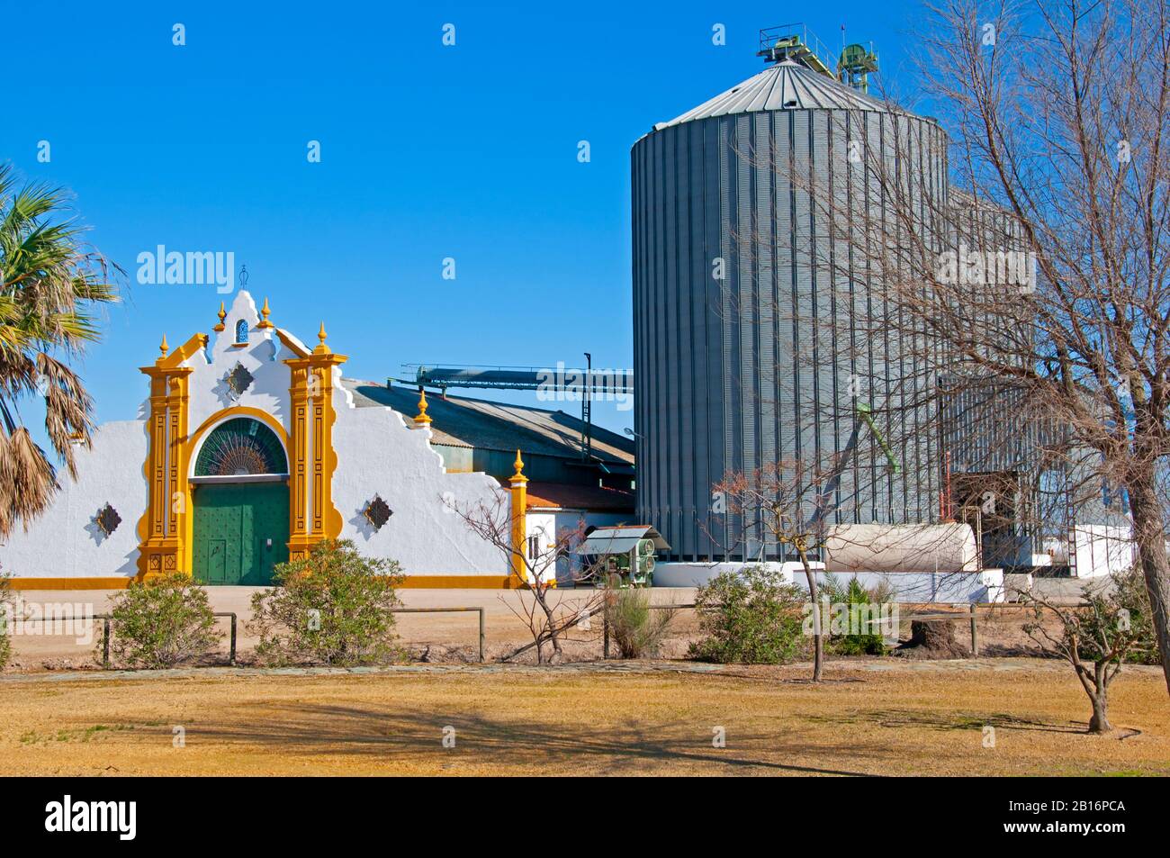 Beautiful white entrance to the rice factory with two big grain elevators, sunny autumn day. Seville, Spain Stock Photo