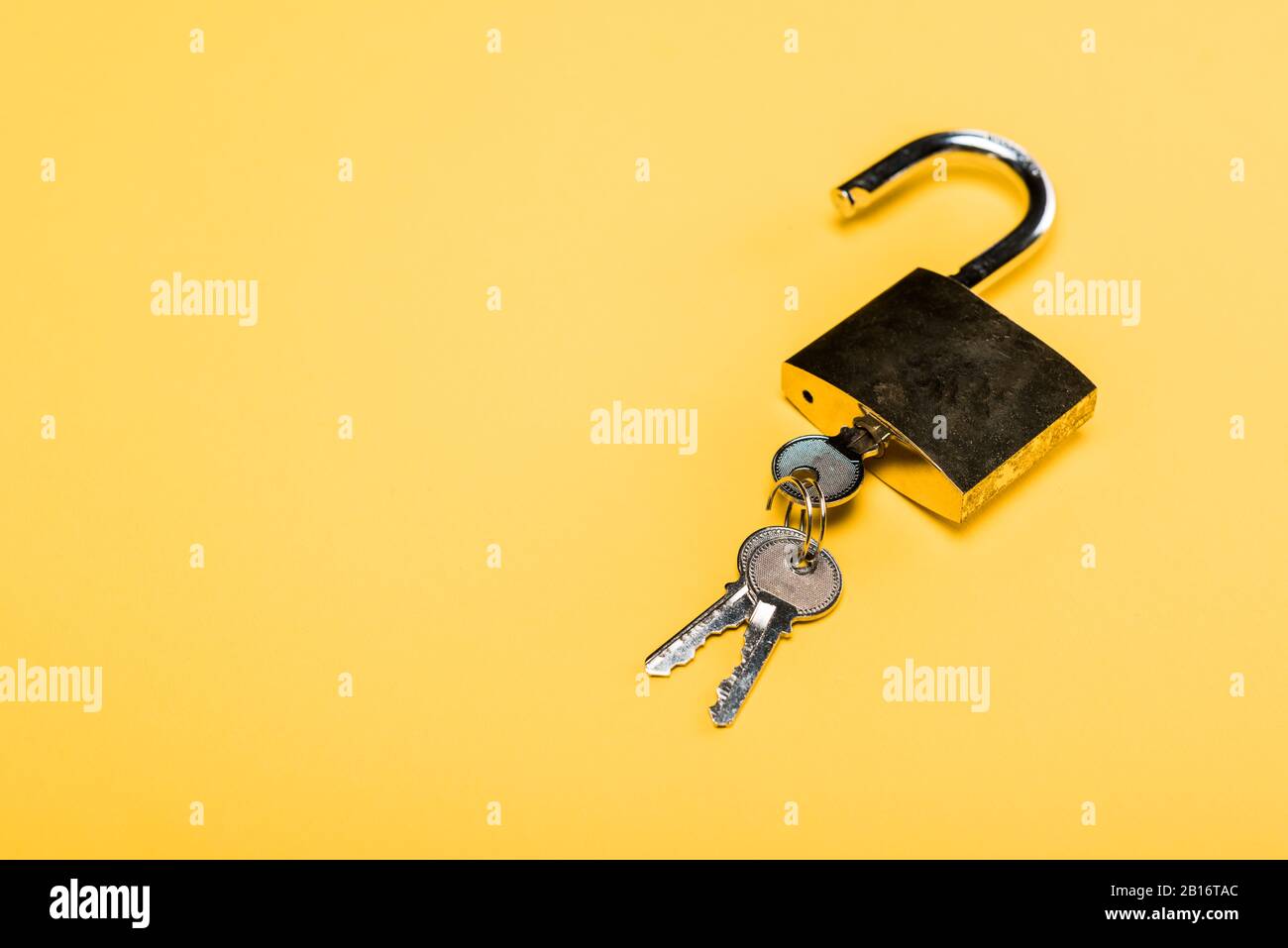 padlock with keys isolated on yellow Stock Photo