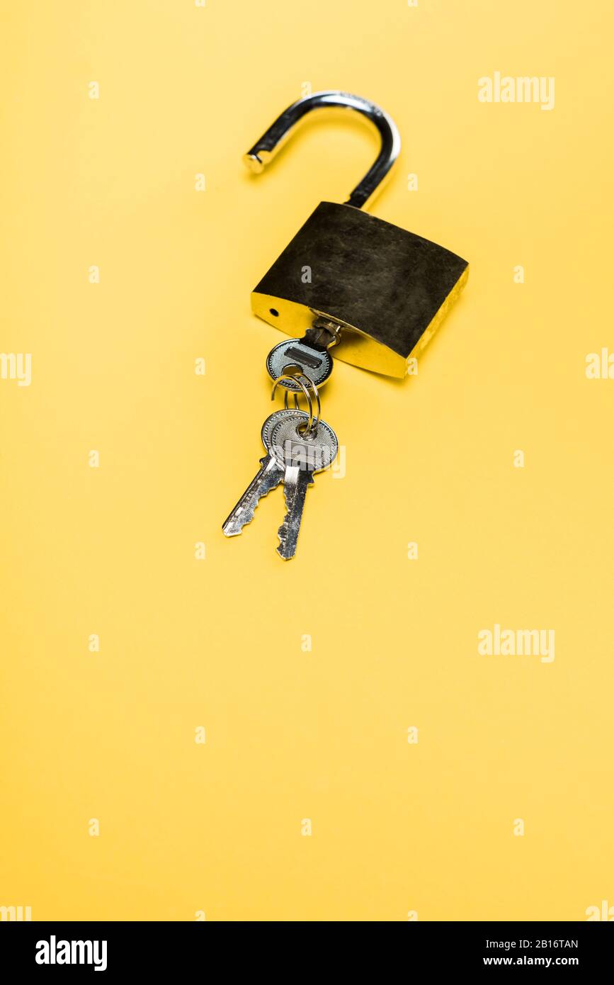 metallic padlock with keys isolated on yellow Stock Photo
