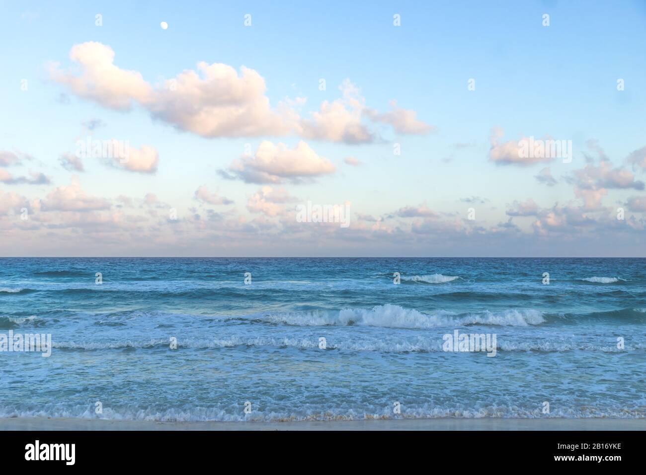 Beach and waves with turquoise water during sunset at Cancun, Yucatan