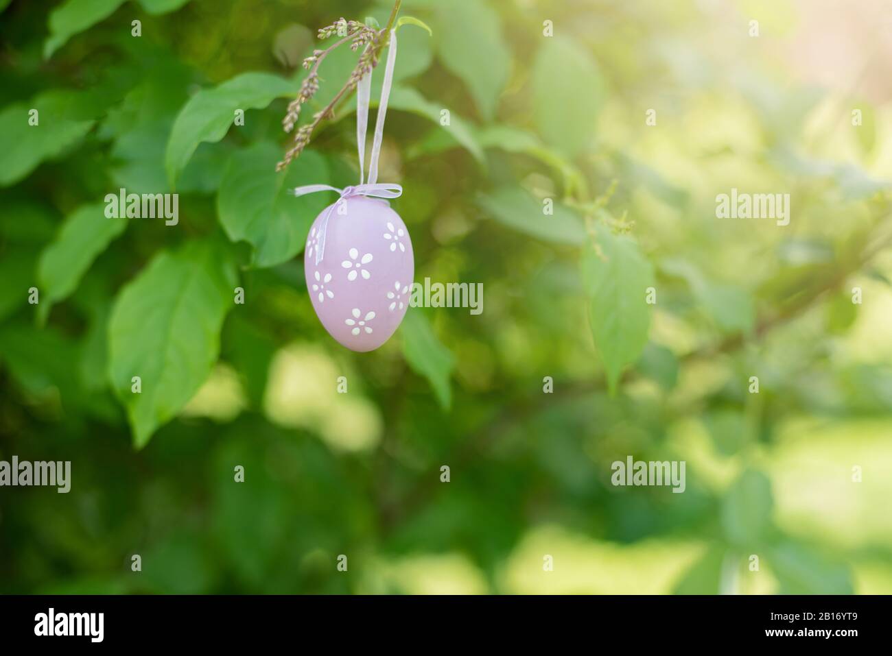 Decorative Easter egg hanging on flowering tree. Easter background ...