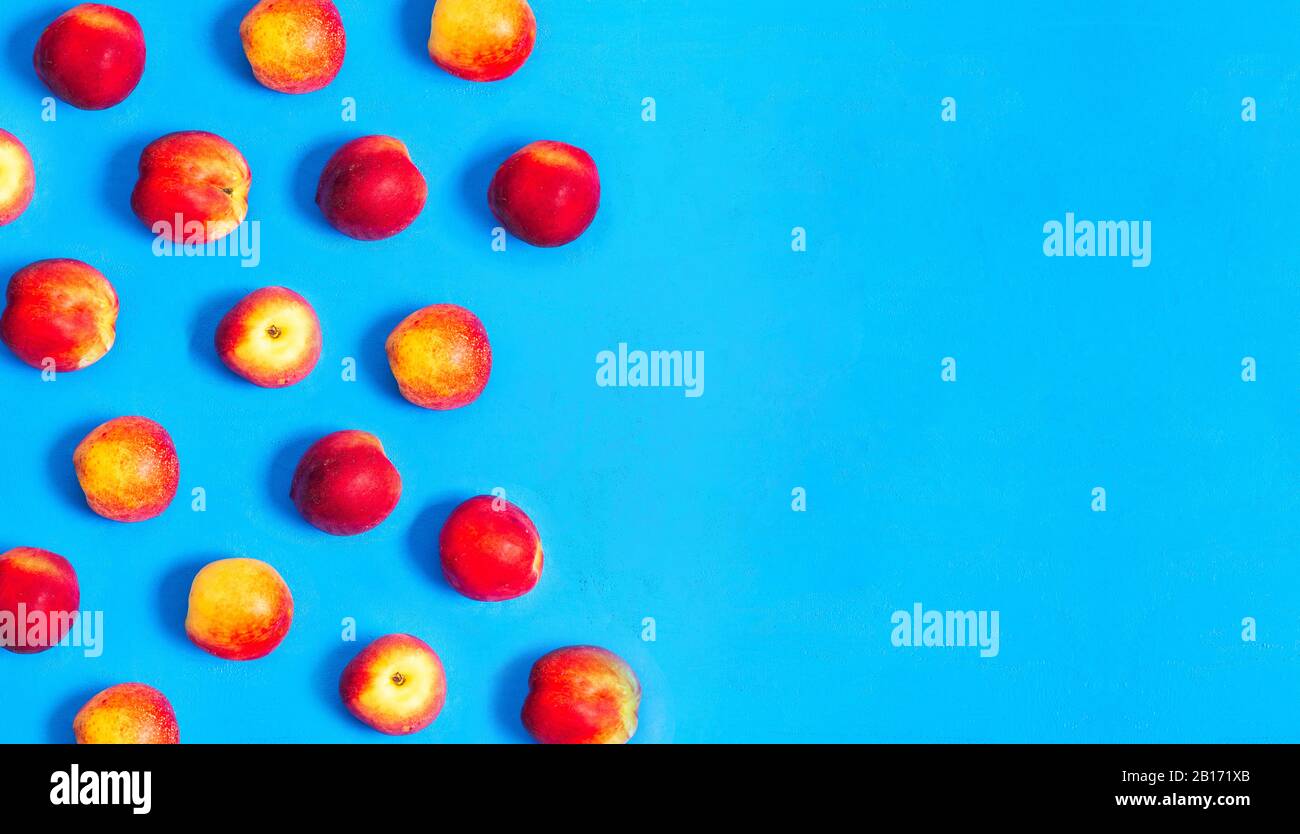 Peaches background, top view. Flat lay of ripe peaches on a blue background. Summer fruits Stock Photo