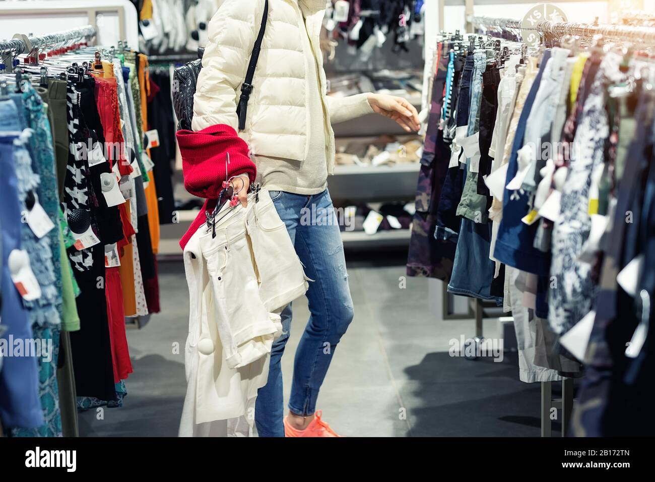 Young adult beautiful woman choosing clothes at market or retail clothing  store in mall indoors. Sale discount season at fashion boutique. Casual  Stock Photo - Alamy