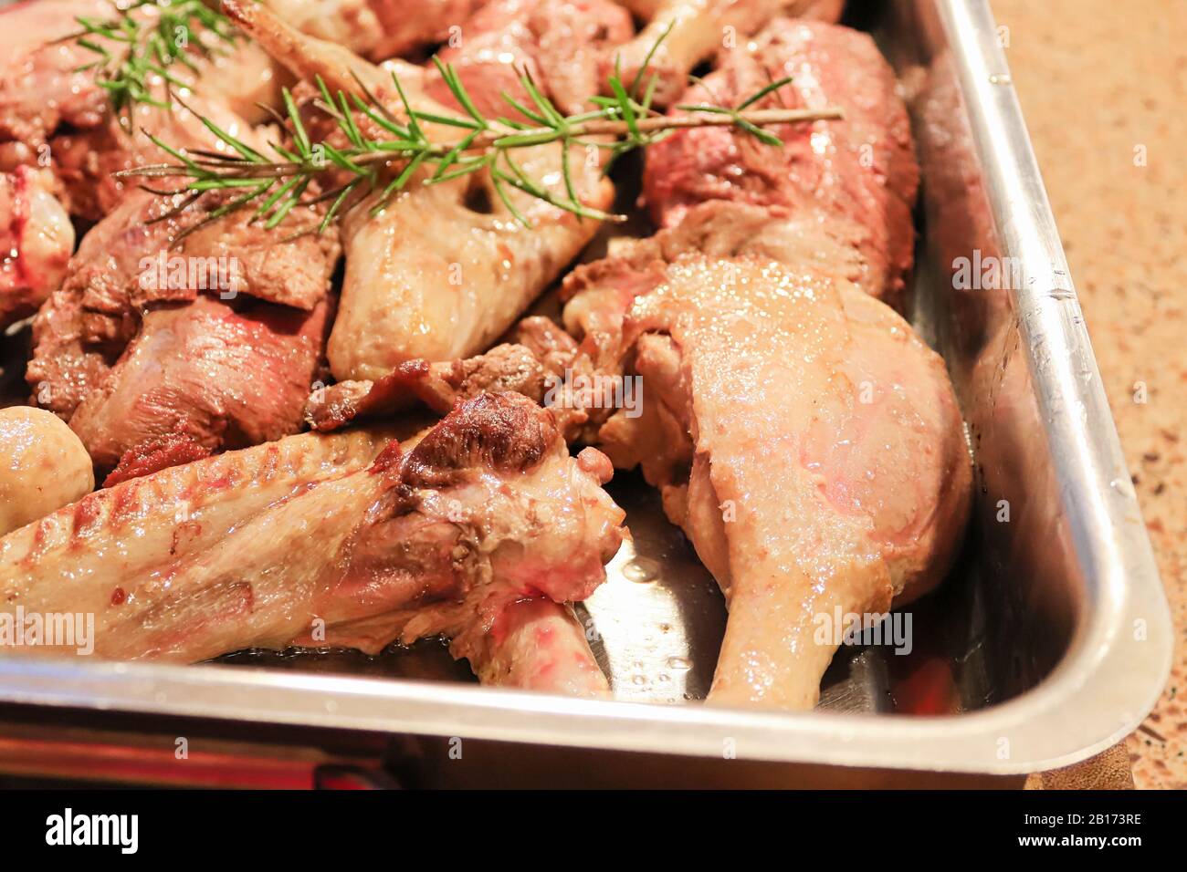 Closeup of cut up raw browned duck parts in a roating pan Stock Photo